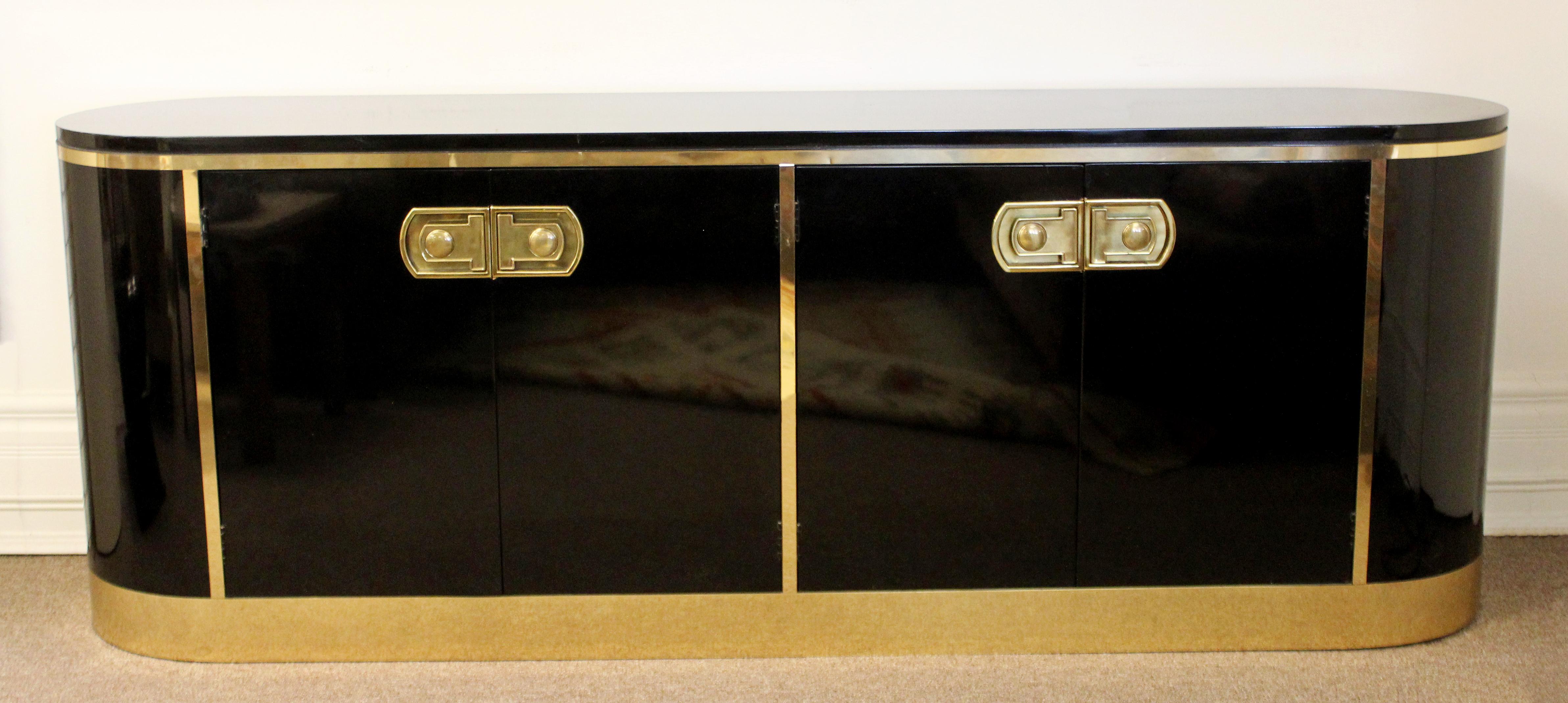 For your consideration is a ravishing, black lacquer credenza, with brass pulls and trims, with four drawers and a shelf, from Mastercraft, circa 1970s. In excellent vintage condition. The dimensions are 80