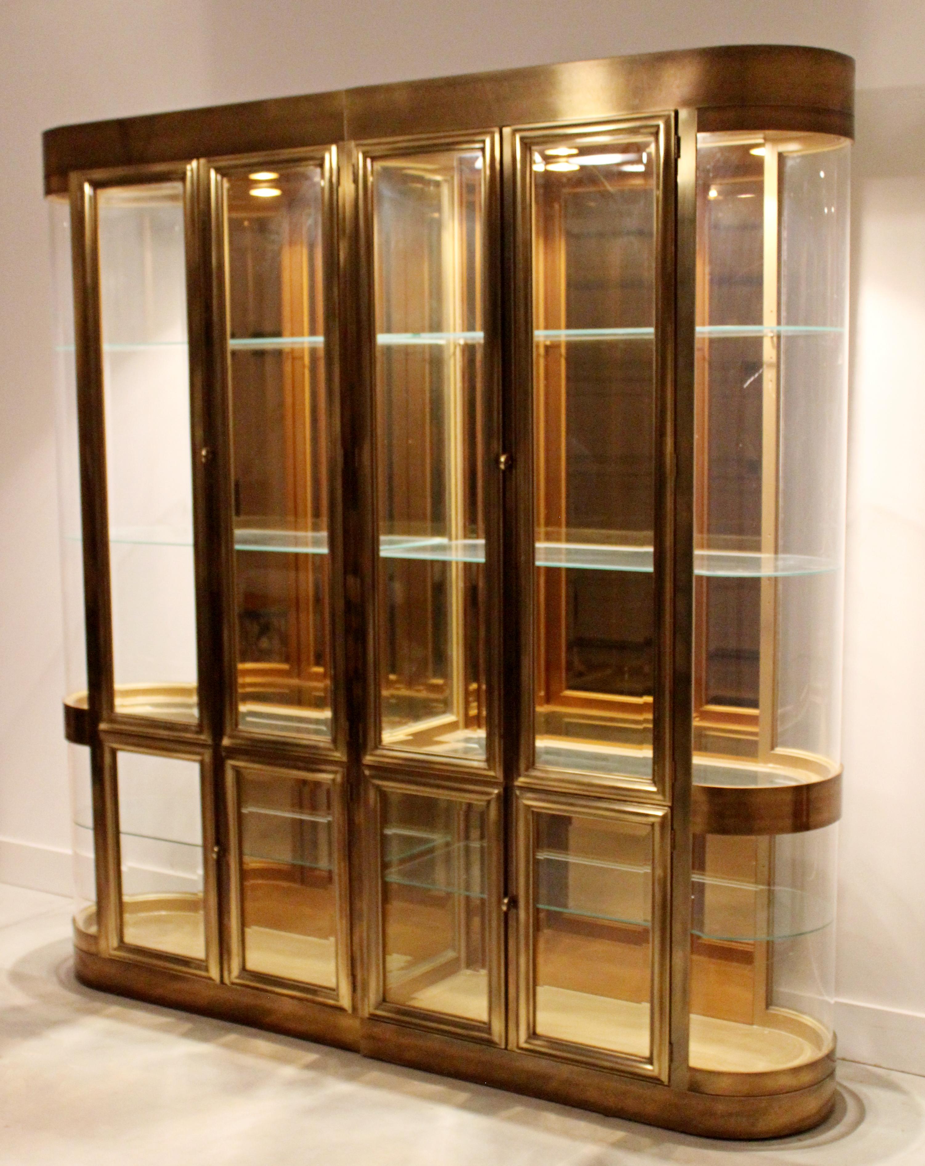For your consideration is a lavish and large, light up, brass and glass shelving unit vitrine, with eight shelves, by Mastercraft, circa 1960s. In good vintage condition, with some surface scratches and a large chip in one of the shelves. The