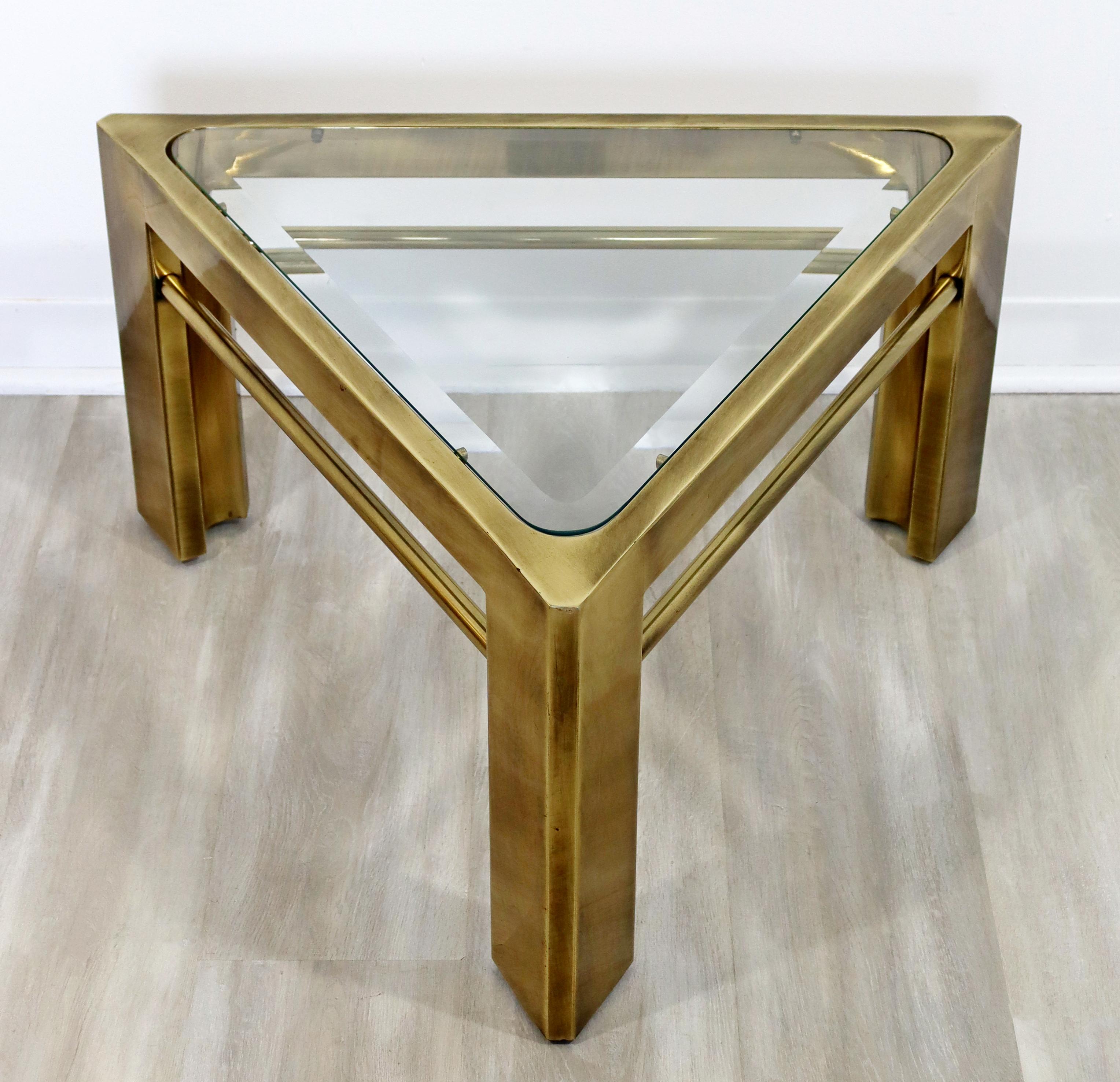 For your consideration is a terrific, triangle shaped coffee table, with a glass top on a brass base, by Mastercraft, circa the 1960s. In excellent vintage condition. The dimensions are 29