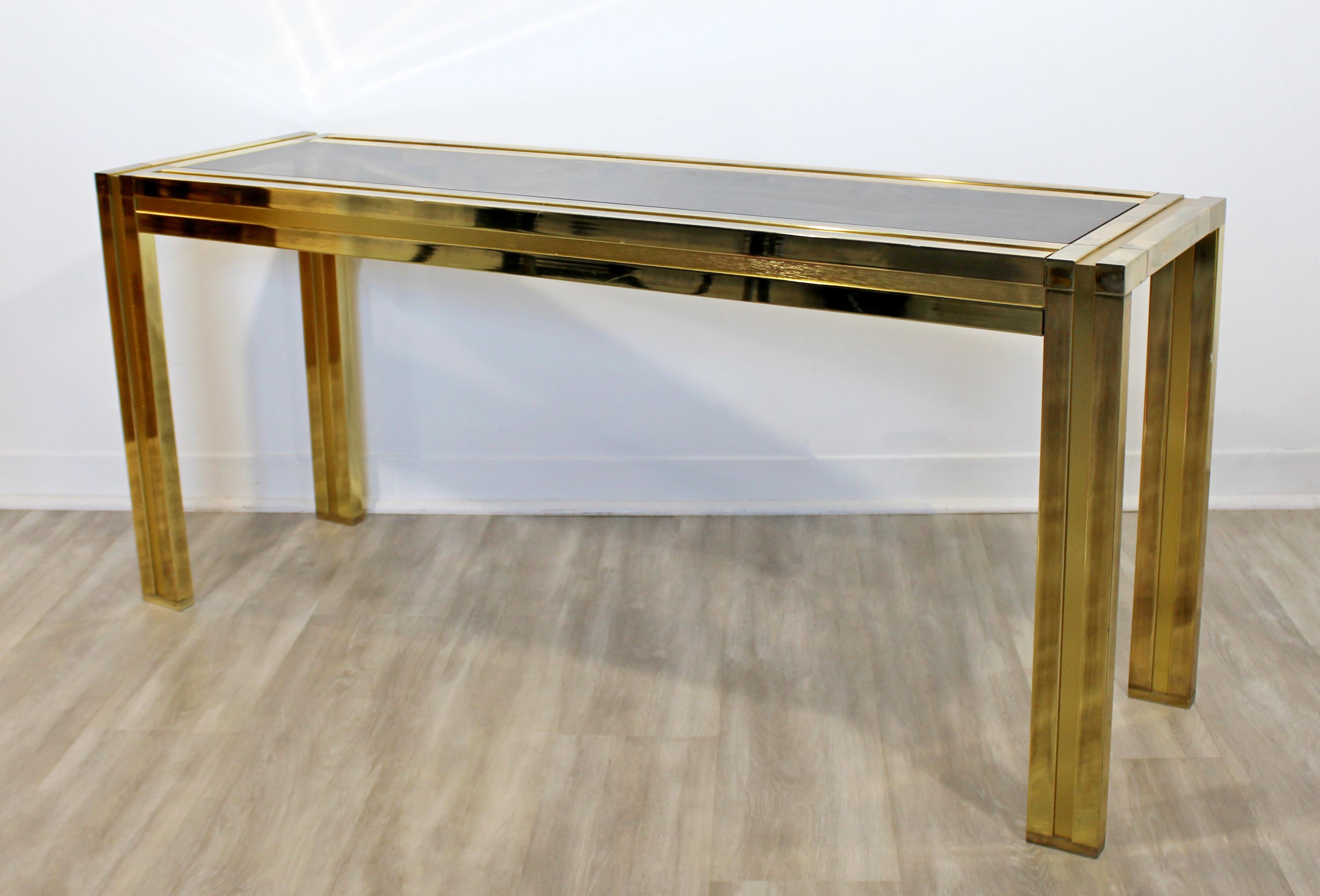 For your consideration is a brilliant, brass console table, with a smoked glass top insert, by Mastercraft, circa 1970s. In excellent vintage condition, with a patina to match its age. The dimensions are 54