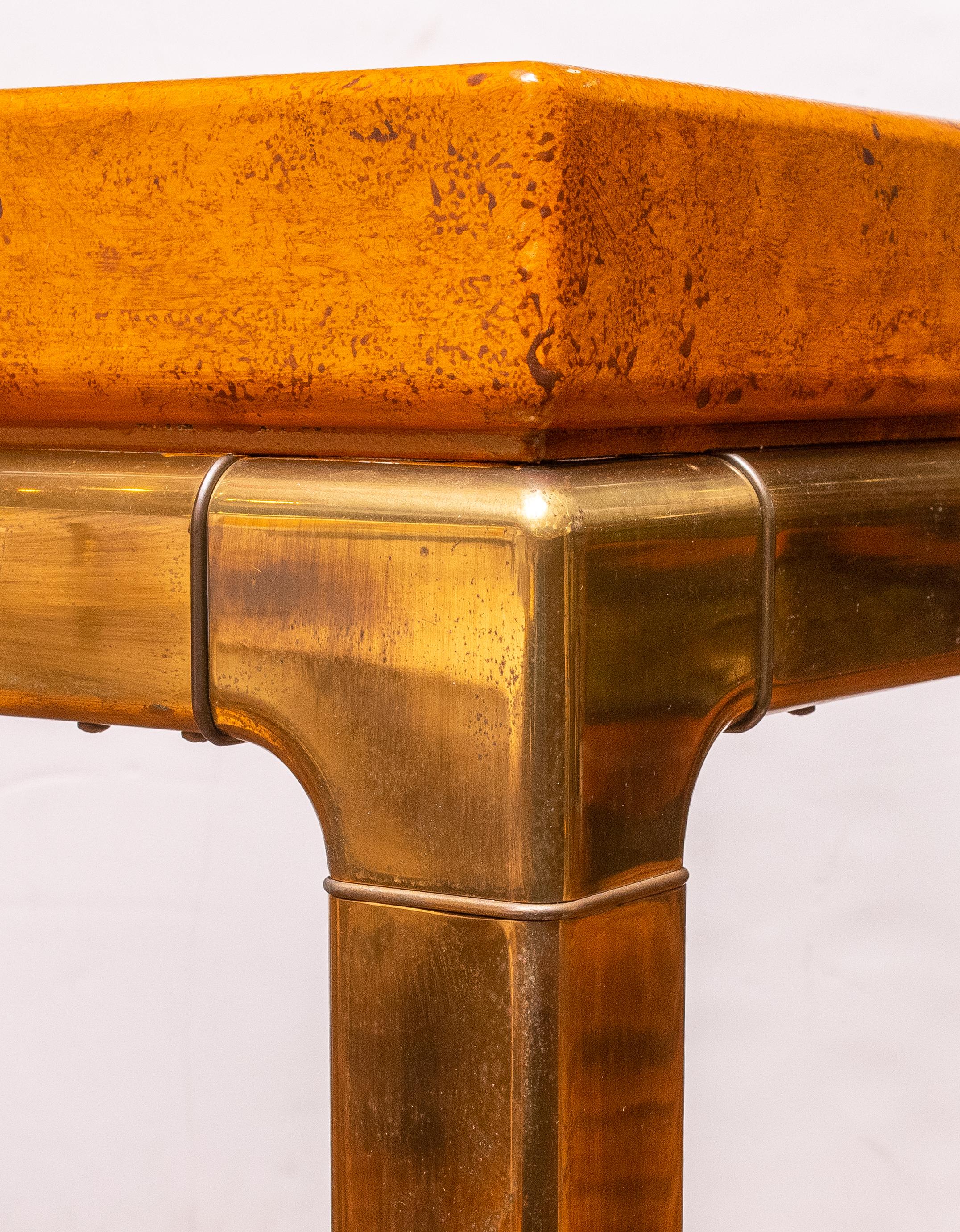 Mid-Century Modern Mastercraft Console with Classic heavy Brass Legs and Frame. Pumpkin/Orange colored Faux Leather textured top with Brass inset Detail.