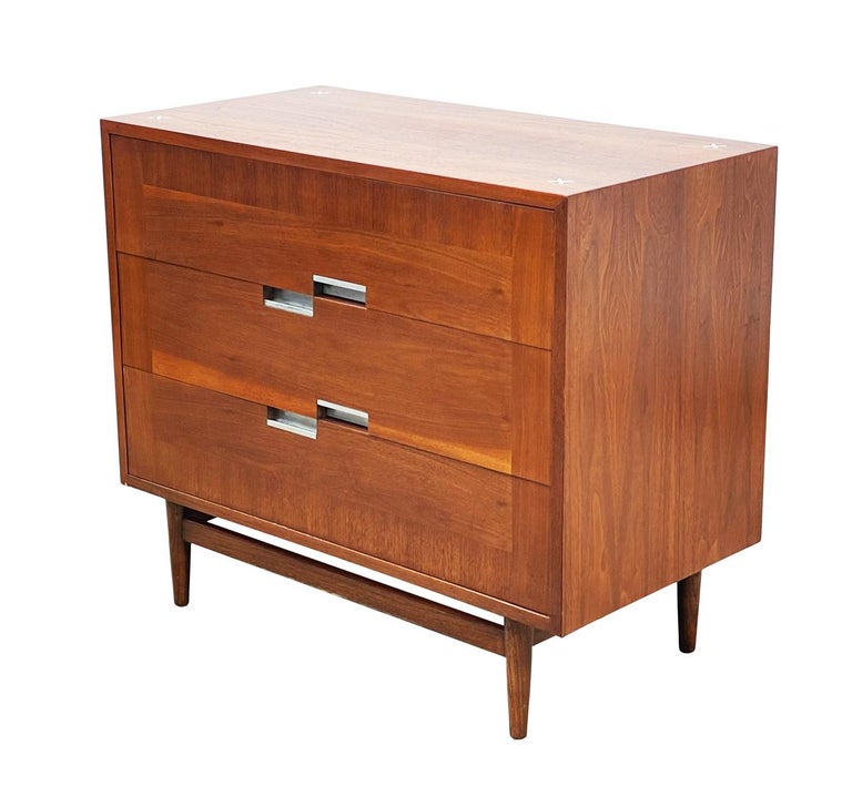 A handsome clean line pair of chests by American of Martinsville from the 1960's. They feature beautifully grained walnut with aluminum hardware. Price includes the pair.