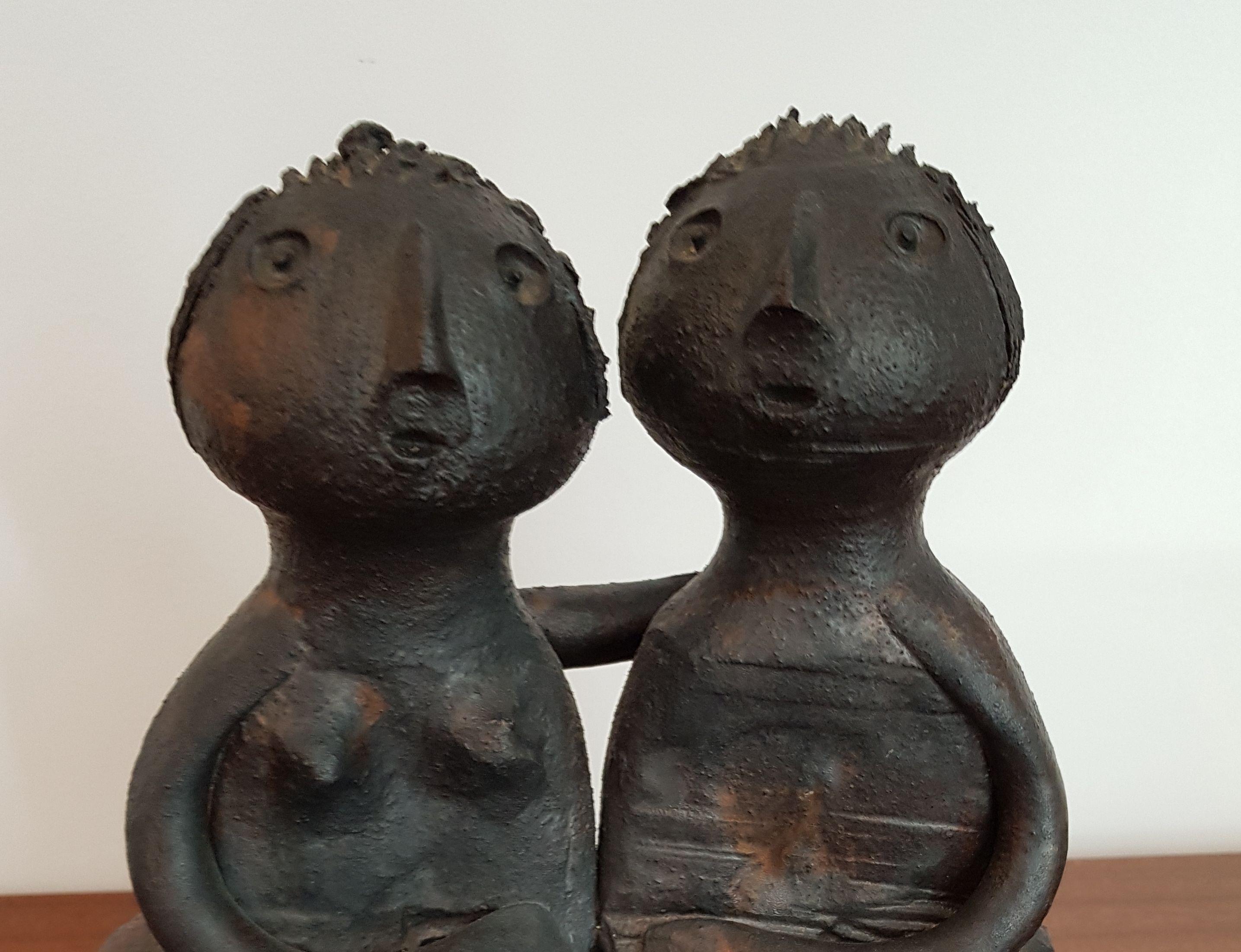 Matt glazed sculptural group of man and woman, signed Dominic Pouchain.