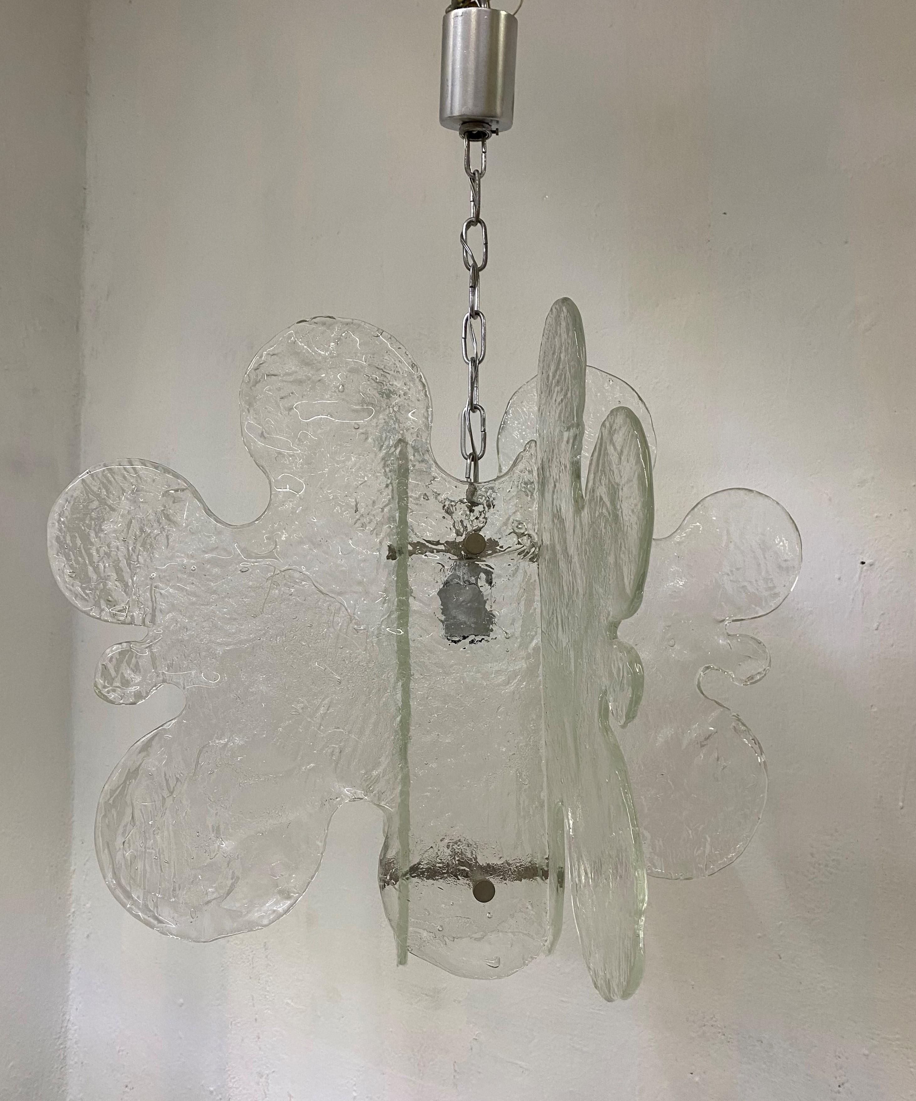 Beautiful Mid-Century Modern chandelier manufactured by Mazzega and designed by Carlo Nason in clear hand blown Murano glass.
It consists of four separate pieces of glass joined together.