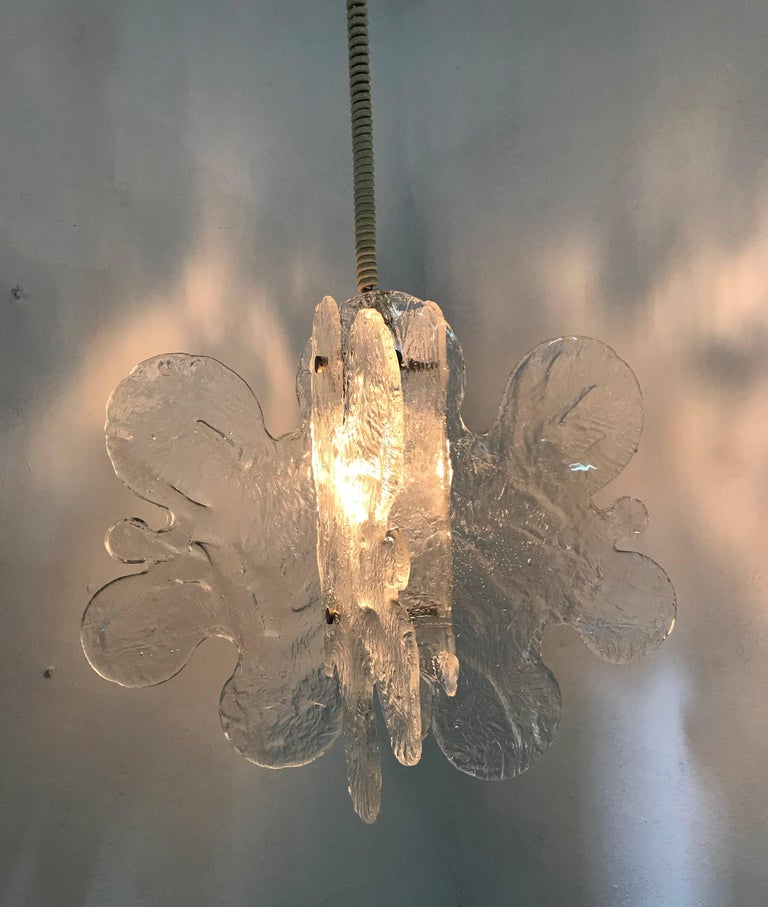 Beautiful Mid-Century Modern chandelier manufactured by Mazzega and designed by Carlo Nason in clear handblown Murano glass.
It consists of four separate panes of glass reminiscent of puzzle pieces joined together.
There is another identical
