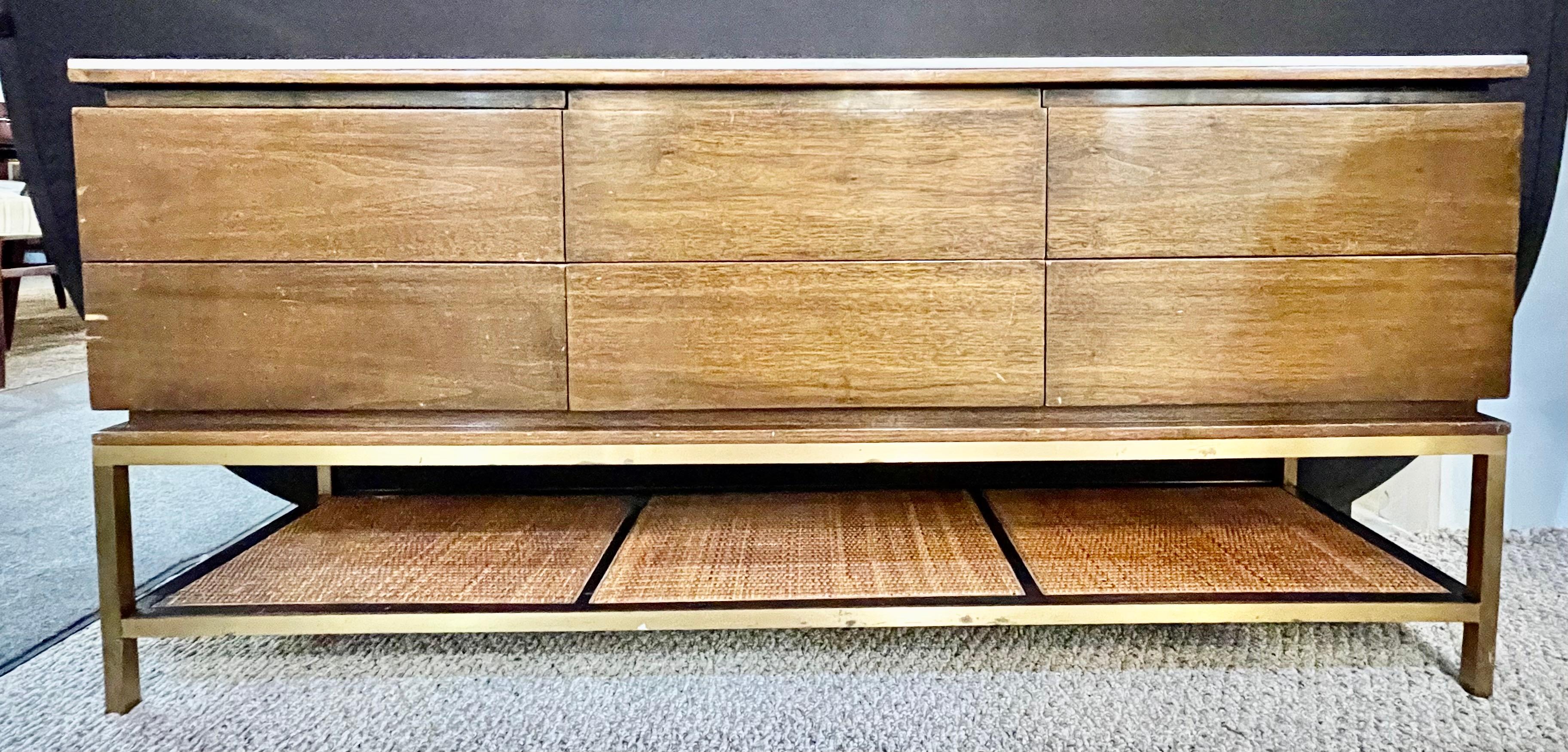 Mid-Century Modern drawer cabinet with glass top brass frame and caning. This finely crafted cabinet is perfect for a living space to sit a television upon. Attributed to Paul McCobb having a brass base with a canned shelve supporting a credenza top