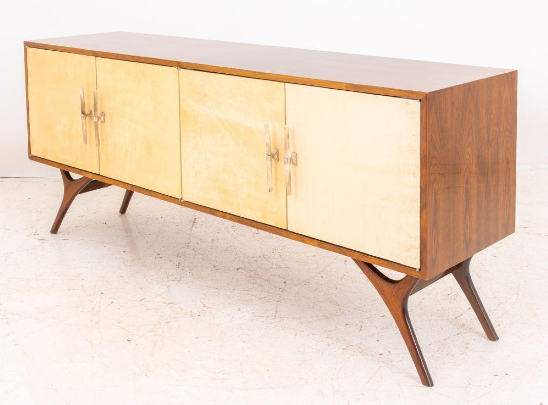 Mid-Century Modern Paul McCobb (American, 1917-1969) manner walnut credenza or sideboard having four cream leather door with horn handles, raised on tapered legs. 30.25