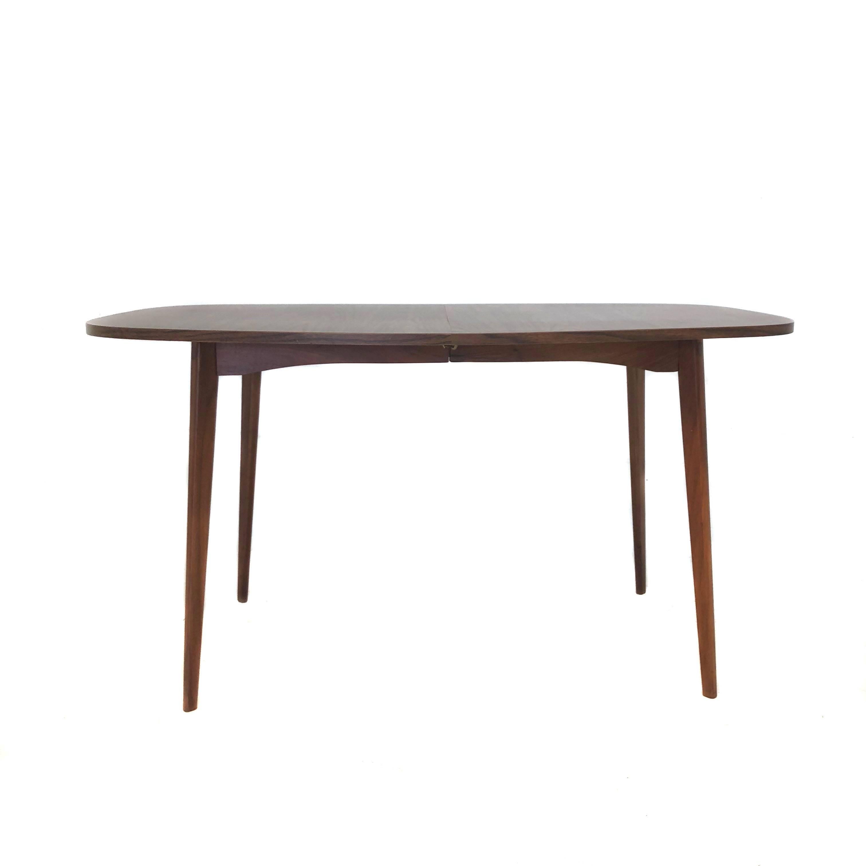 Mid-Century Modern extendable dining table by Mel Smilow with two leaves. In excellent condition with minimal age appropriate wear. Made from walnut laminate with matching grain.

Measurements:
Without leaves 53