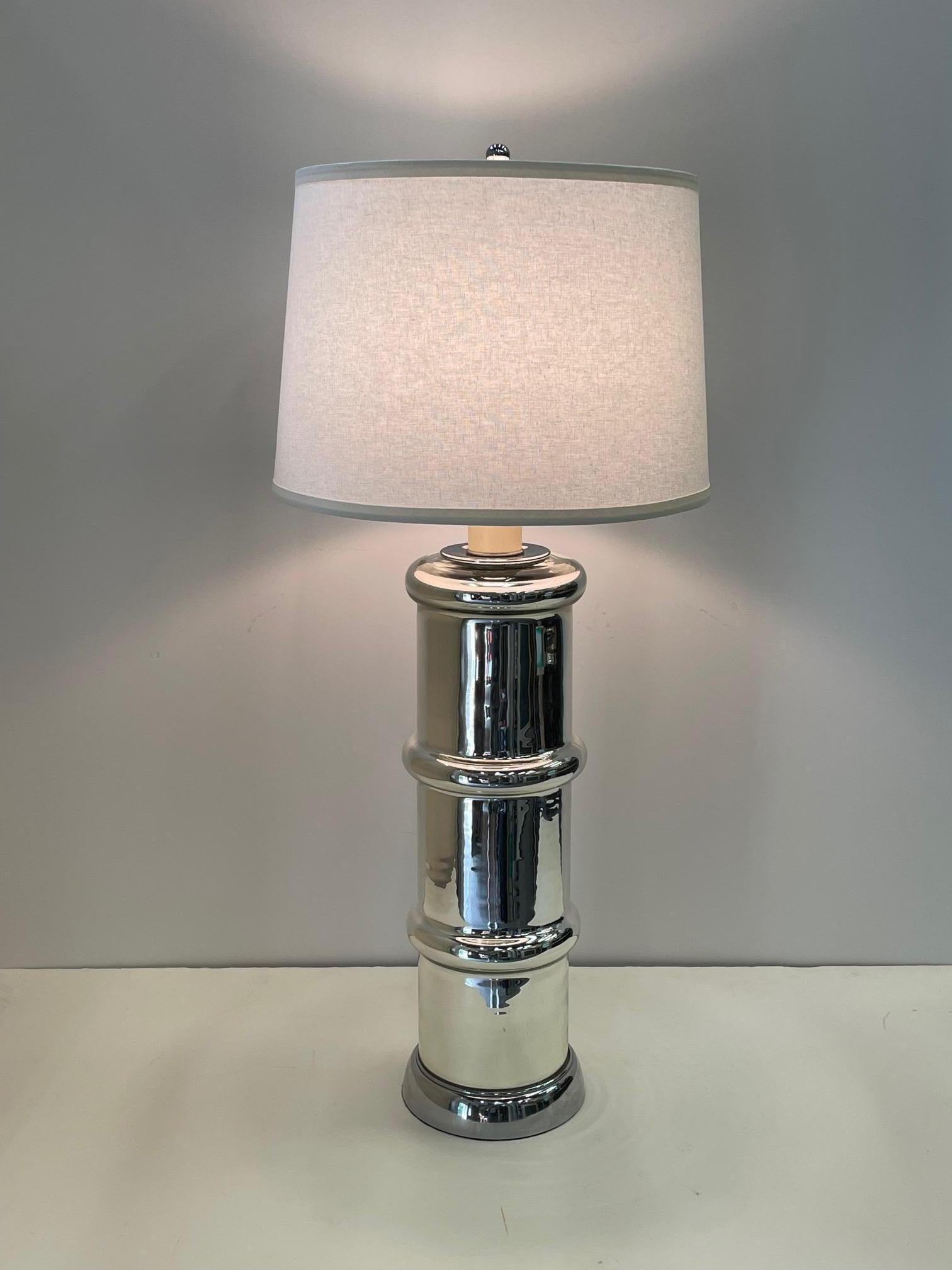 A stylish Mid-Century Modern glistening mercury glass columnar table lamp having faux bamboo design.