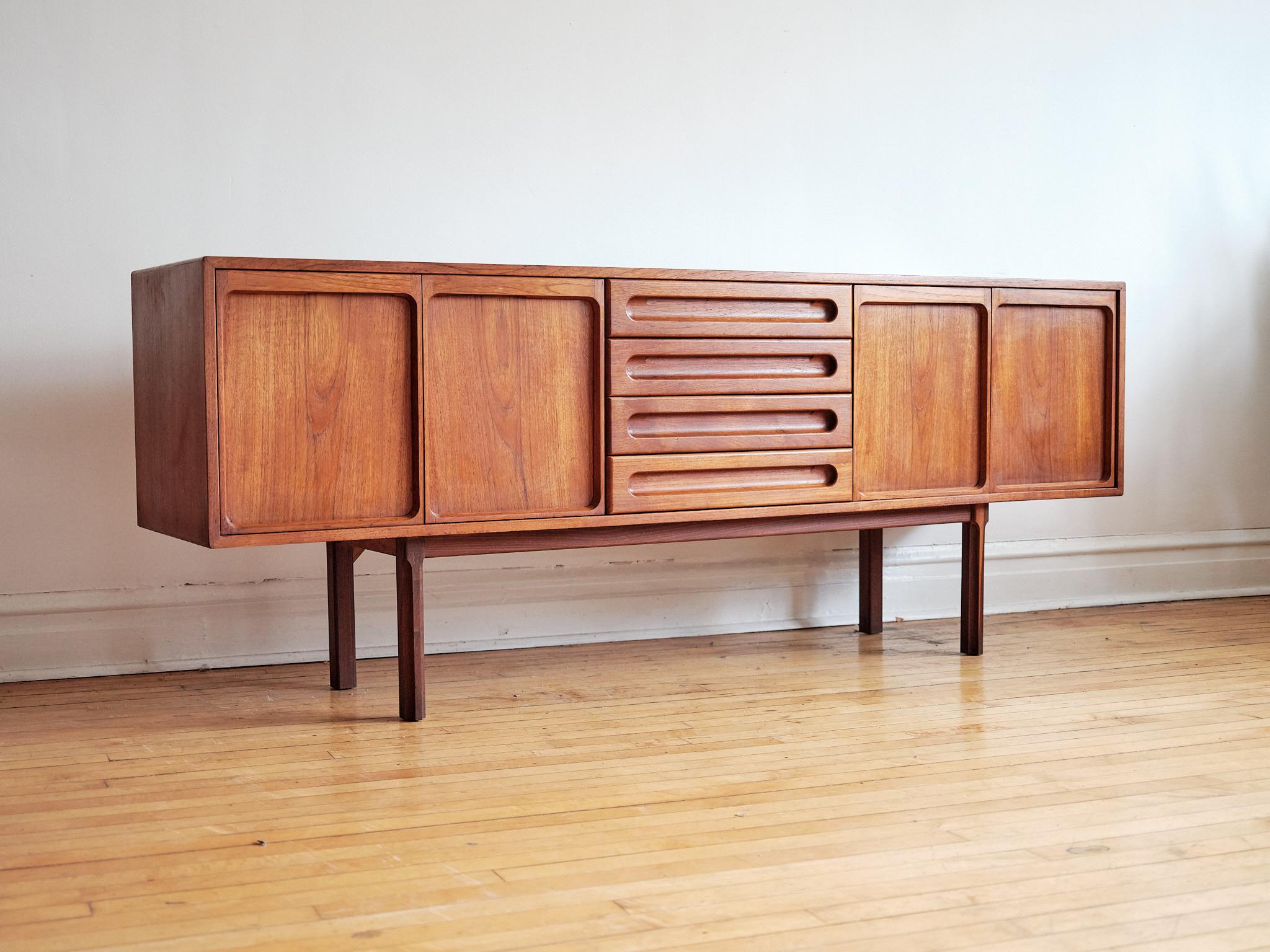 Mid-century Danish Modern teakwood sideboard by Meredew.
Just imported from England.
Four dovetailed drawers; top drawer holds dividers.
Each double cabinet holds a shelf.
Excellent vintage condition.

Measures: 78” long x 18” depth x 30 5/8”