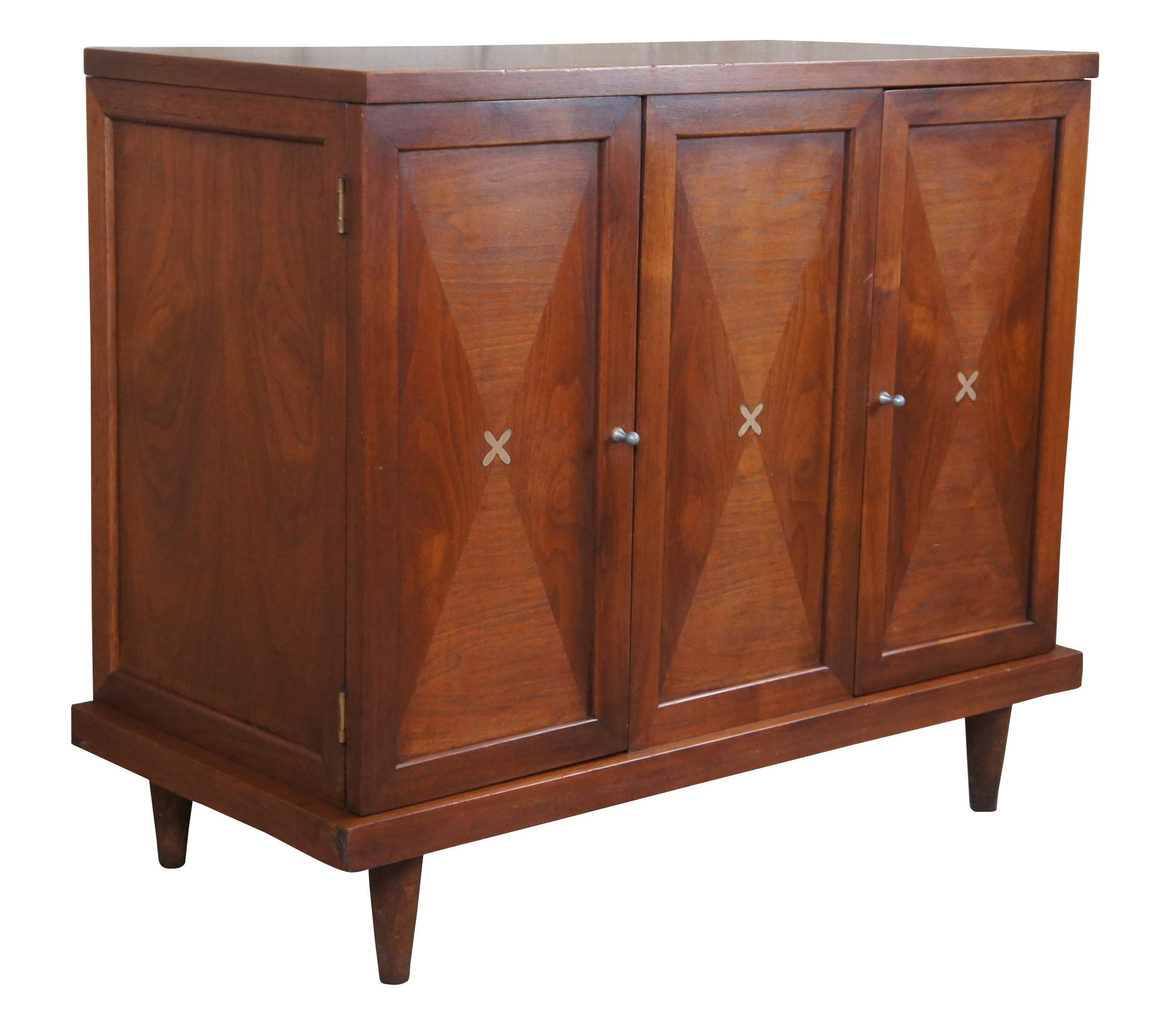 Mid-Century Modern Accord chest designed by Merton Gershun for American of Martinsville, no 3759. A rectangular form with a plinth base raised over turned and tapered legs. Made of walnut featuring matchbook veneered inset panelled front with