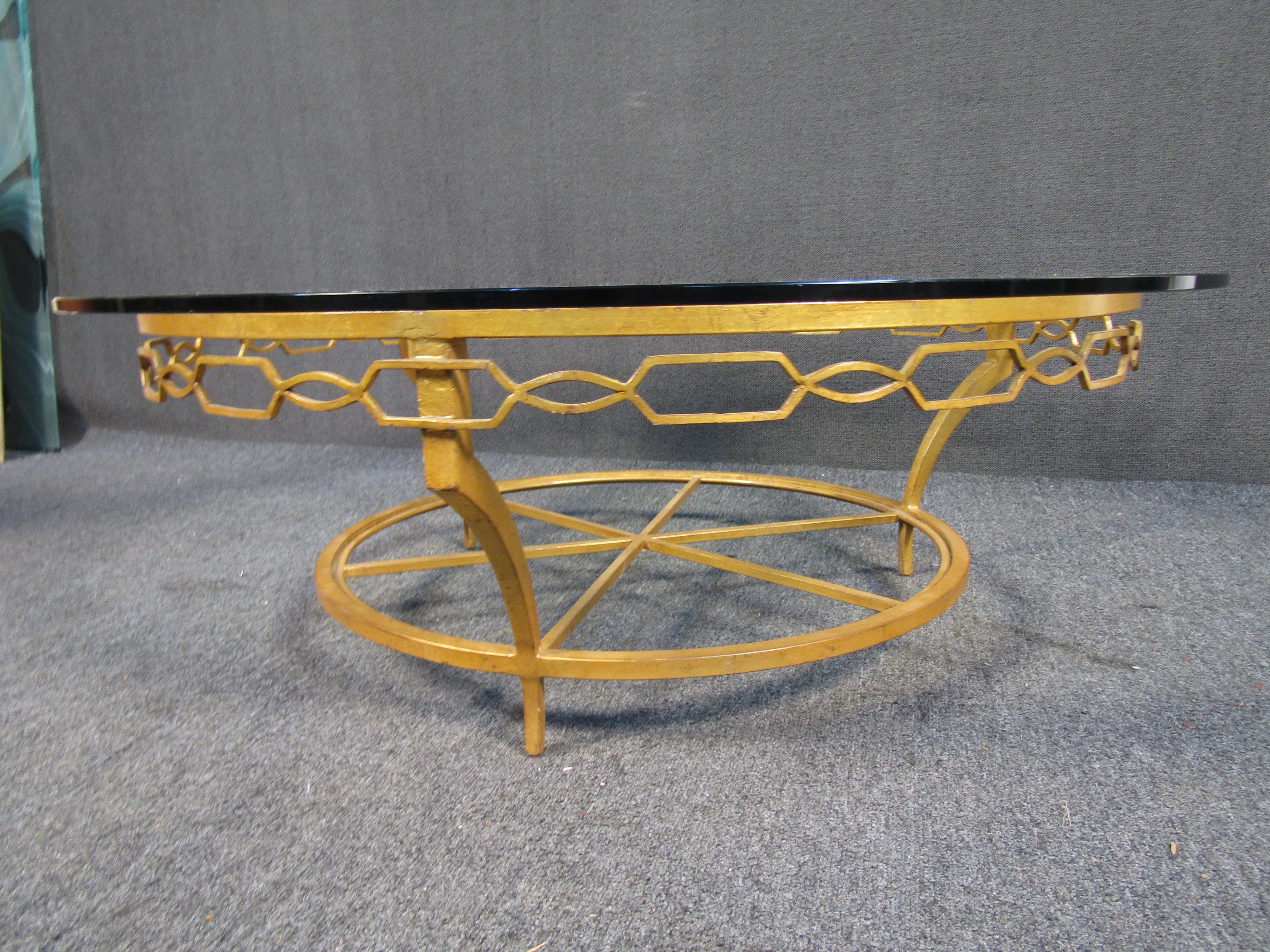 This vintage gold coffee table showcases a ornate metal base through its circular glass top. Perfect for enjoying coffee or drinks with company. This Mid-Century Modern table is stylish, sturdy and a perfect center piece to any living space.

