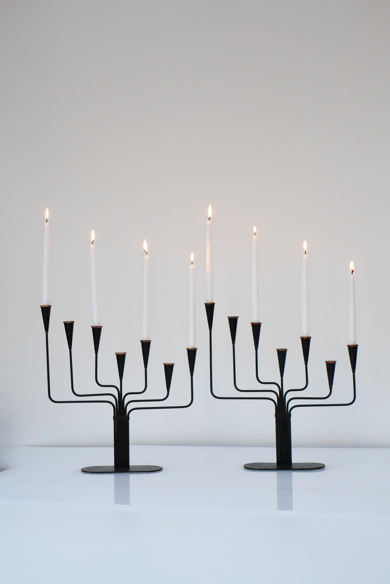 A very nice pair of vintage candlestick holders designed by Gunnar Ander in the 1960s and produced by Ystad Metal in Sweden. The shape is very simple yet still very elegant and sophisticated with the irregular seven arms. They are made from black