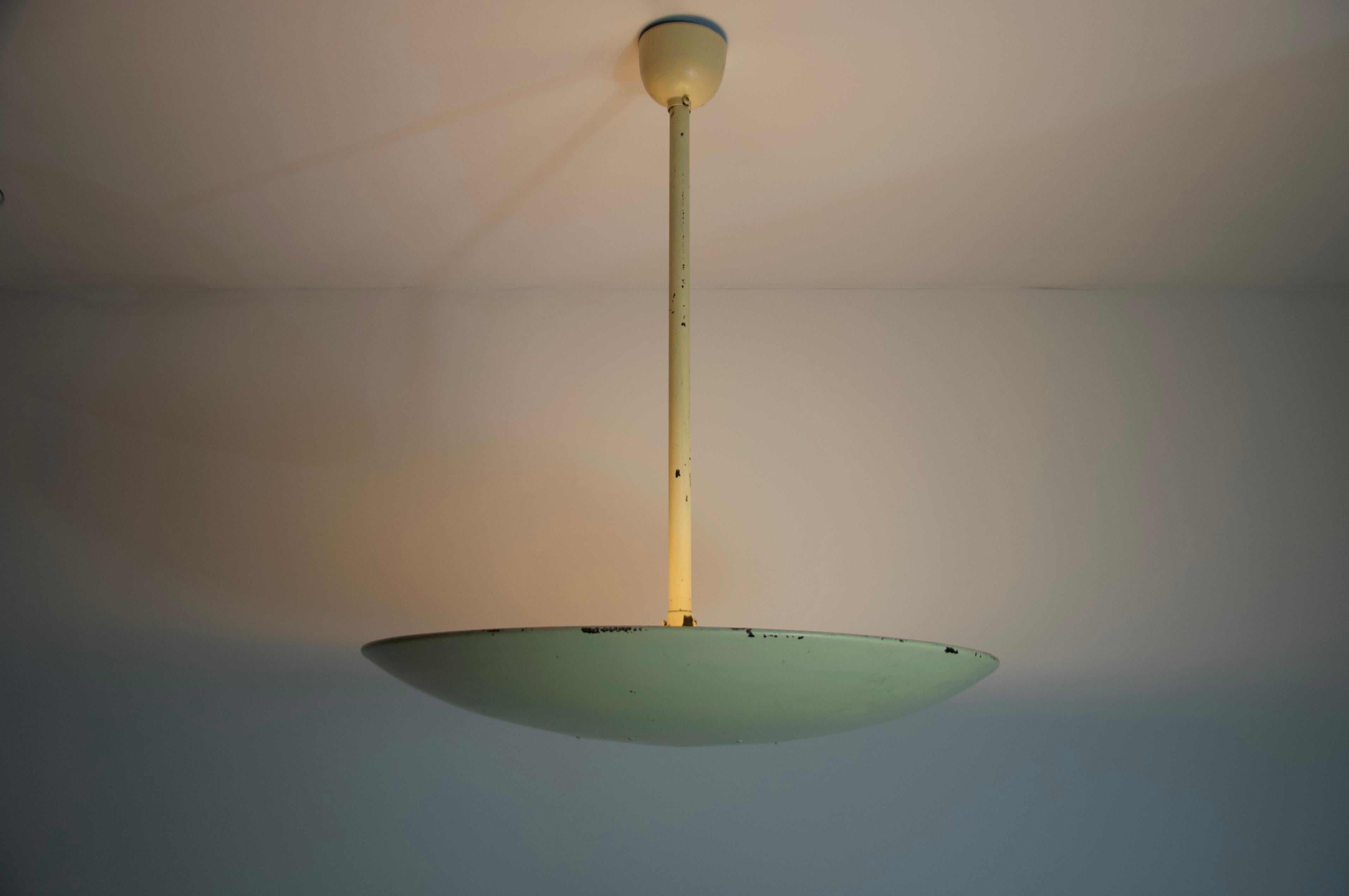 Questa lampada da soffitto in metallo degli anni '60, proveniente dalla Germania, incarna la sobria eleganza del design di metà secolo. Caratterizzata da una forma pulita e minimalista, la lampada presenta una finitura smaltata di colore giallo