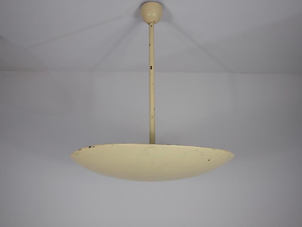 Questa lampada da soffitto in metallo degli anni '60, proveniente dalla Germania, incarna la sobria eleganza del design di metà secolo. Caratterizzata da una forma pulita e minimalista, la lampada presenta una finitura smaltata di colore giallo