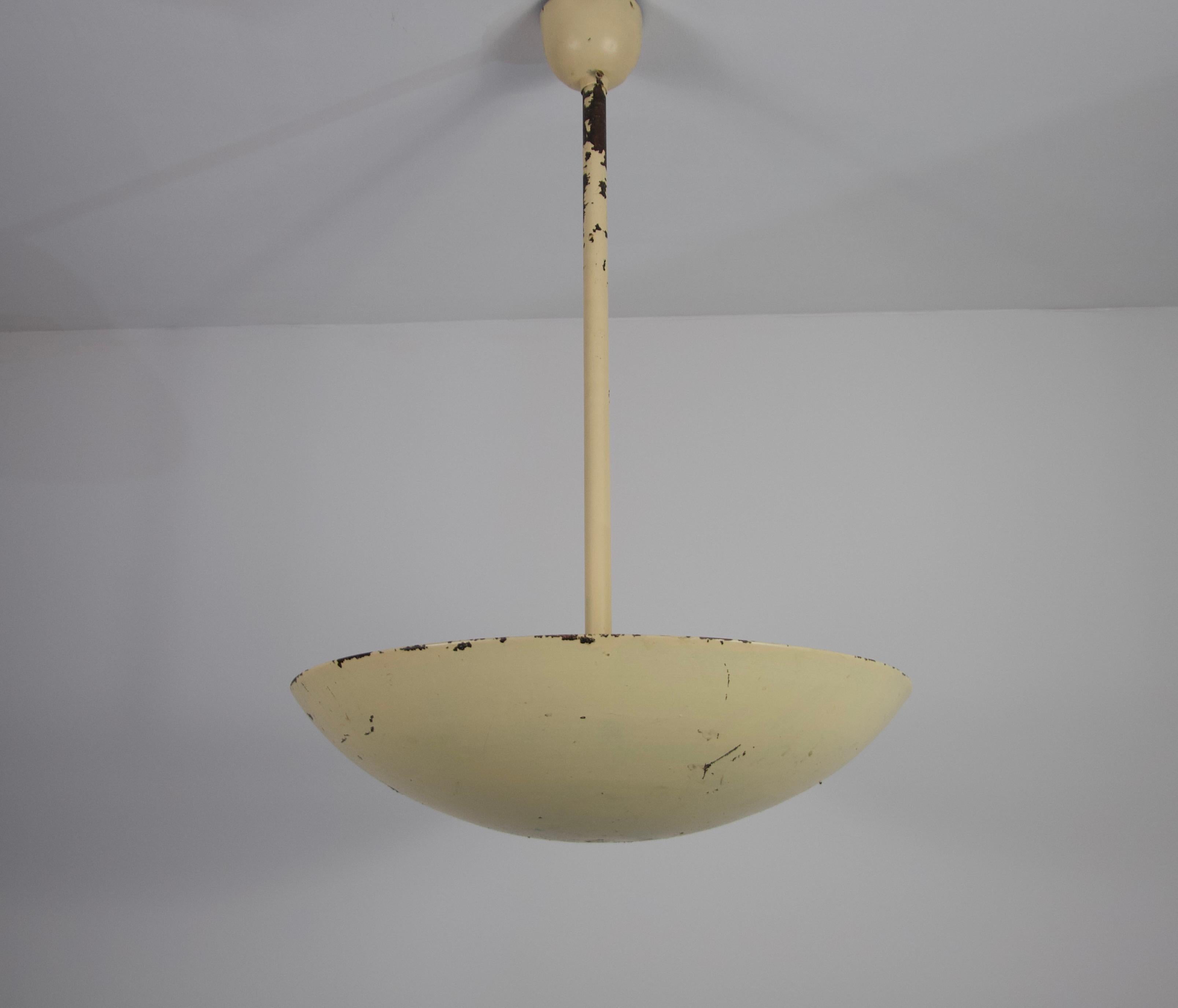 Ce plafonnier en métal allemand des années 1960 incarne l'élégance discrète du design du milieu du siècle. Dotée d'une forme épurée et minimaliste, la lampe présente une finition émaillée jaune tendre qui apporte chaleur et charme subtil à tout