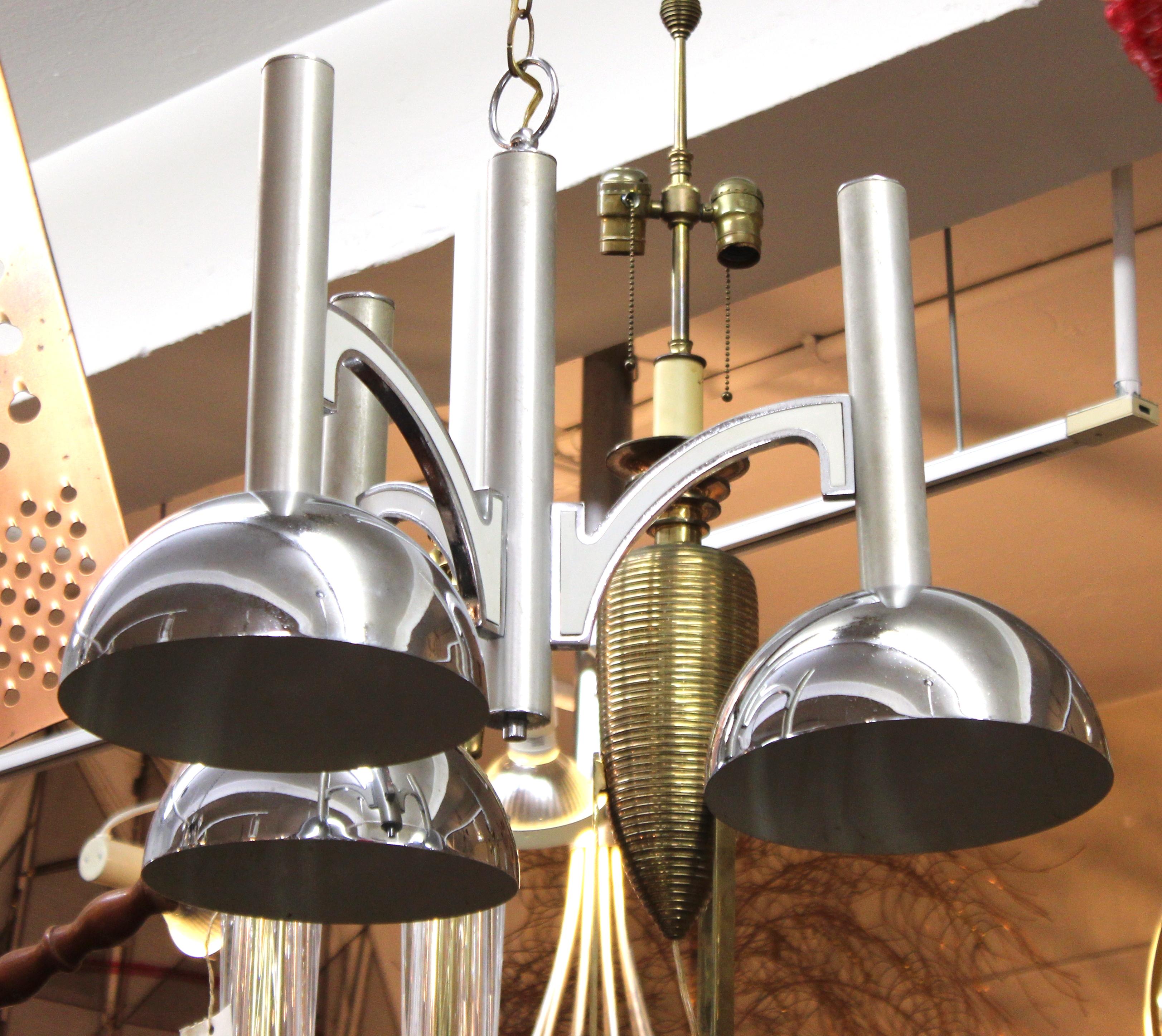 Mid-Century Modern ceiling pendant light made of metal with three shades around a center metal shaft. The piece has elements reminiscent of some machine age designs and was made in the mid-20th century. In great vintage condition with some