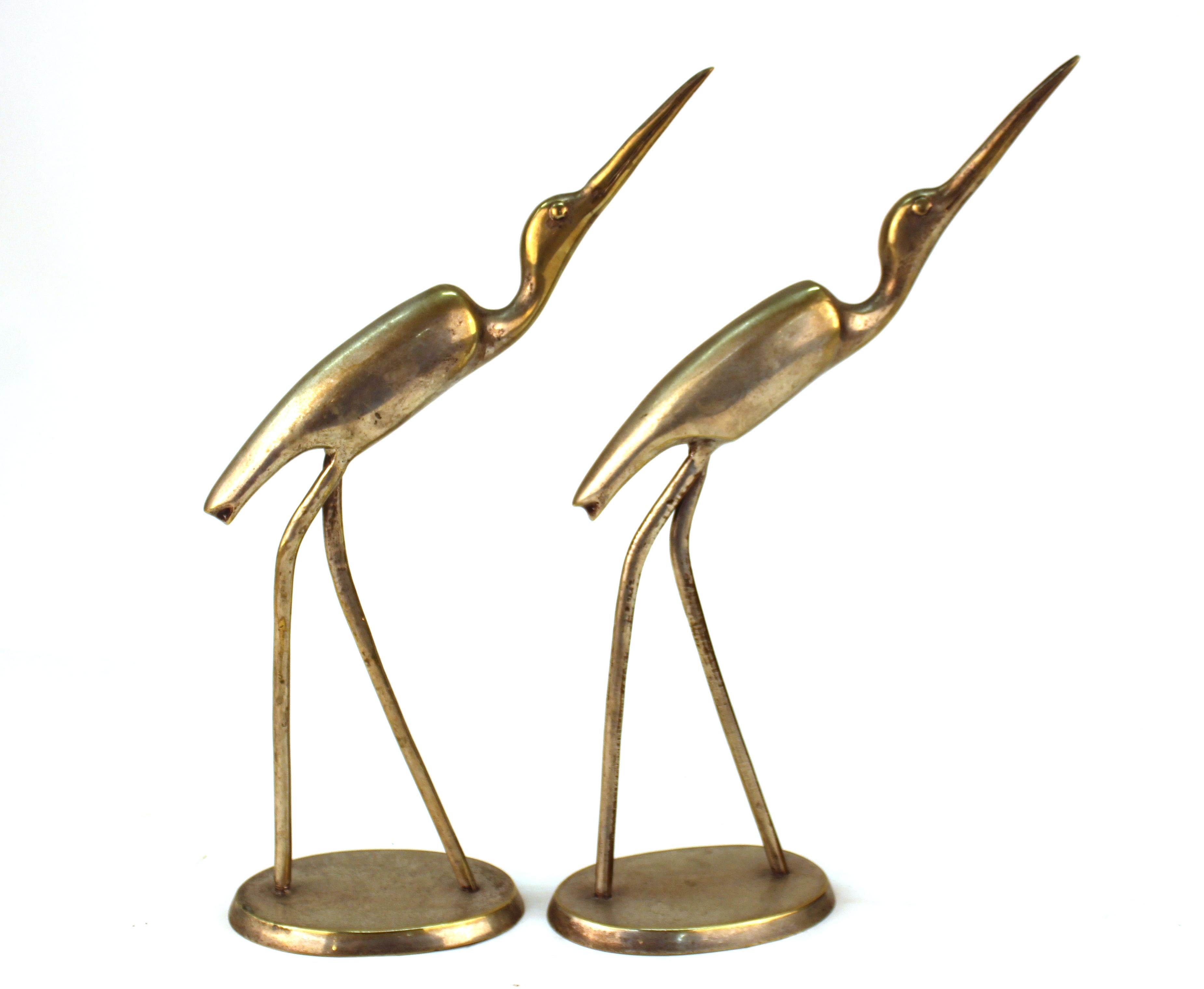 Pair of Mid-Century Modern metal long-legged ibis bird sculptures raising their heads. The pair has a label marked 'made in India and is in great vintage condition, with age-appropriate wear to the metal patina.