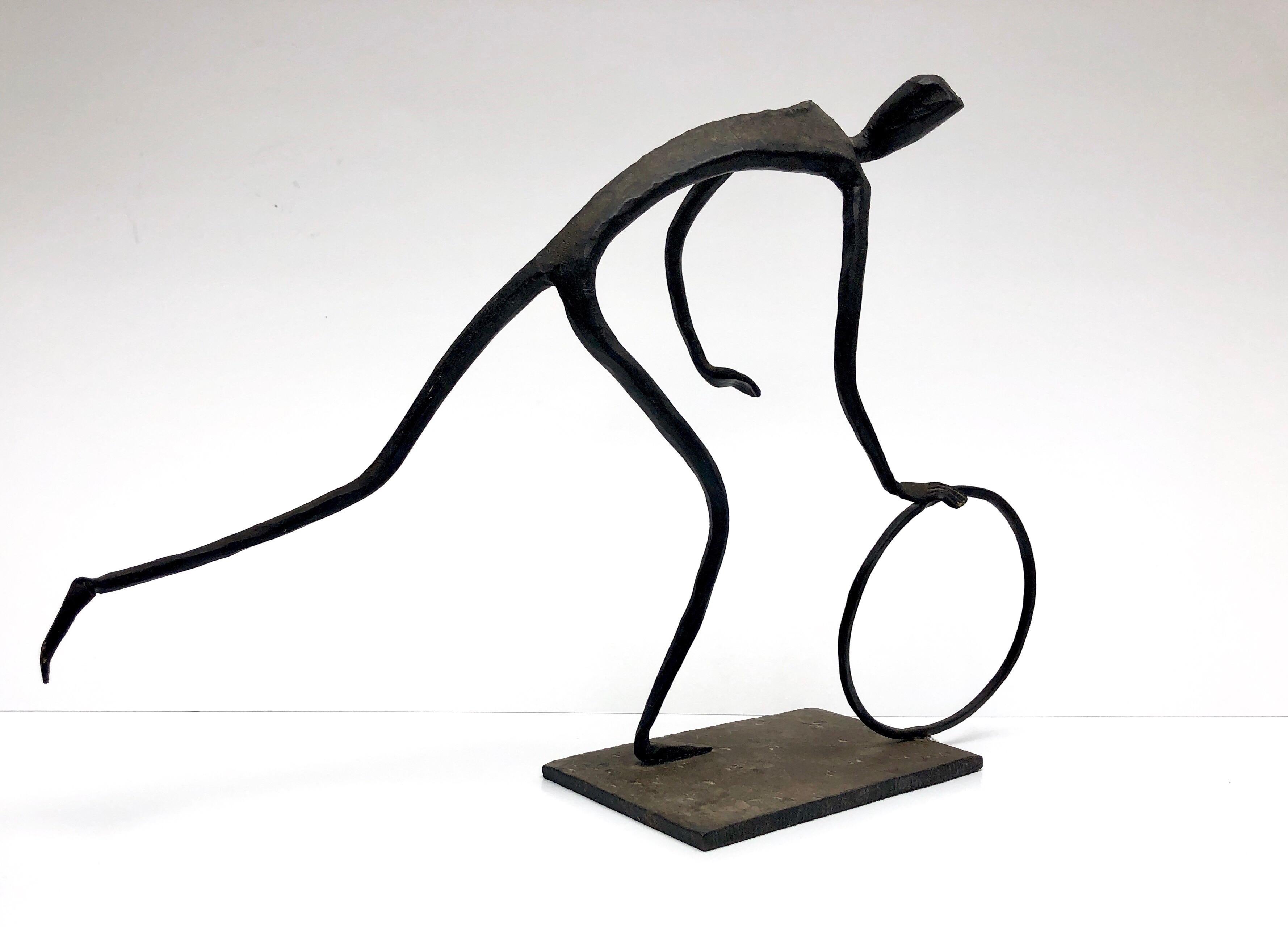 A midcentury stylized sculpture of a man with a rolling a ring, very much in the style of Hagenauer. Great lines and movement.