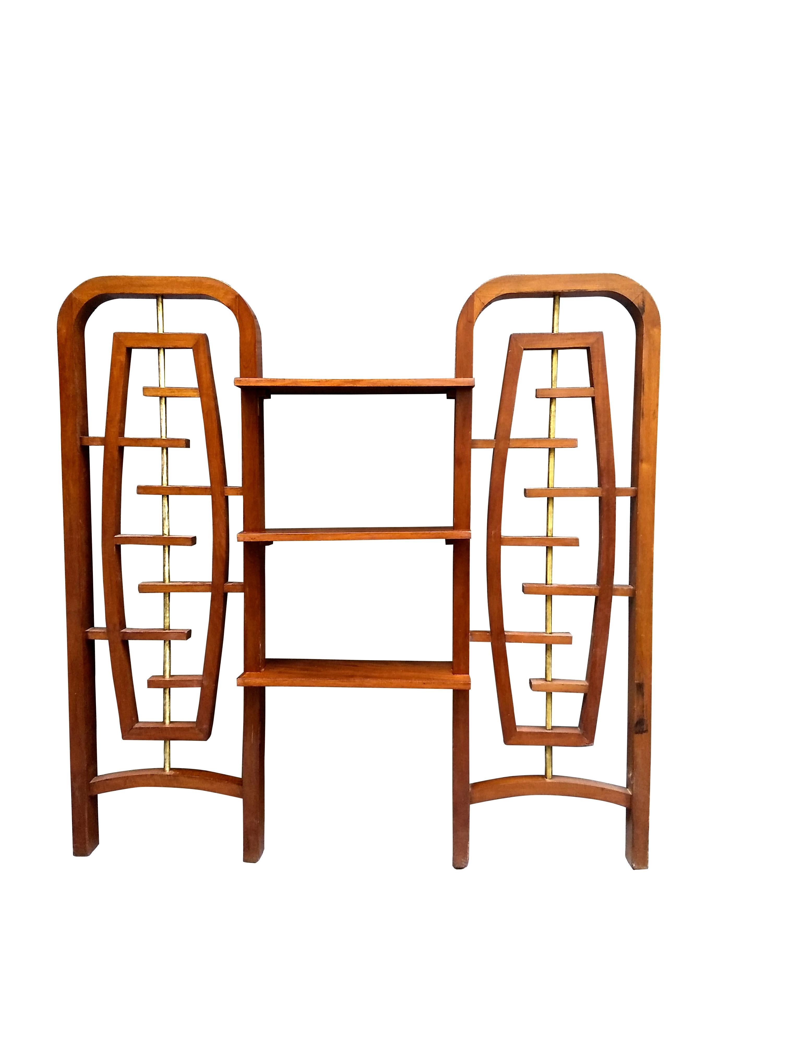 Amazing Mid-Century Modern Mexican room divider formed with two structures in mahogany and polished brass attached by three horizontal shelves in the style of Eugenio Escudero. Each vertical structure features a floating like element within its