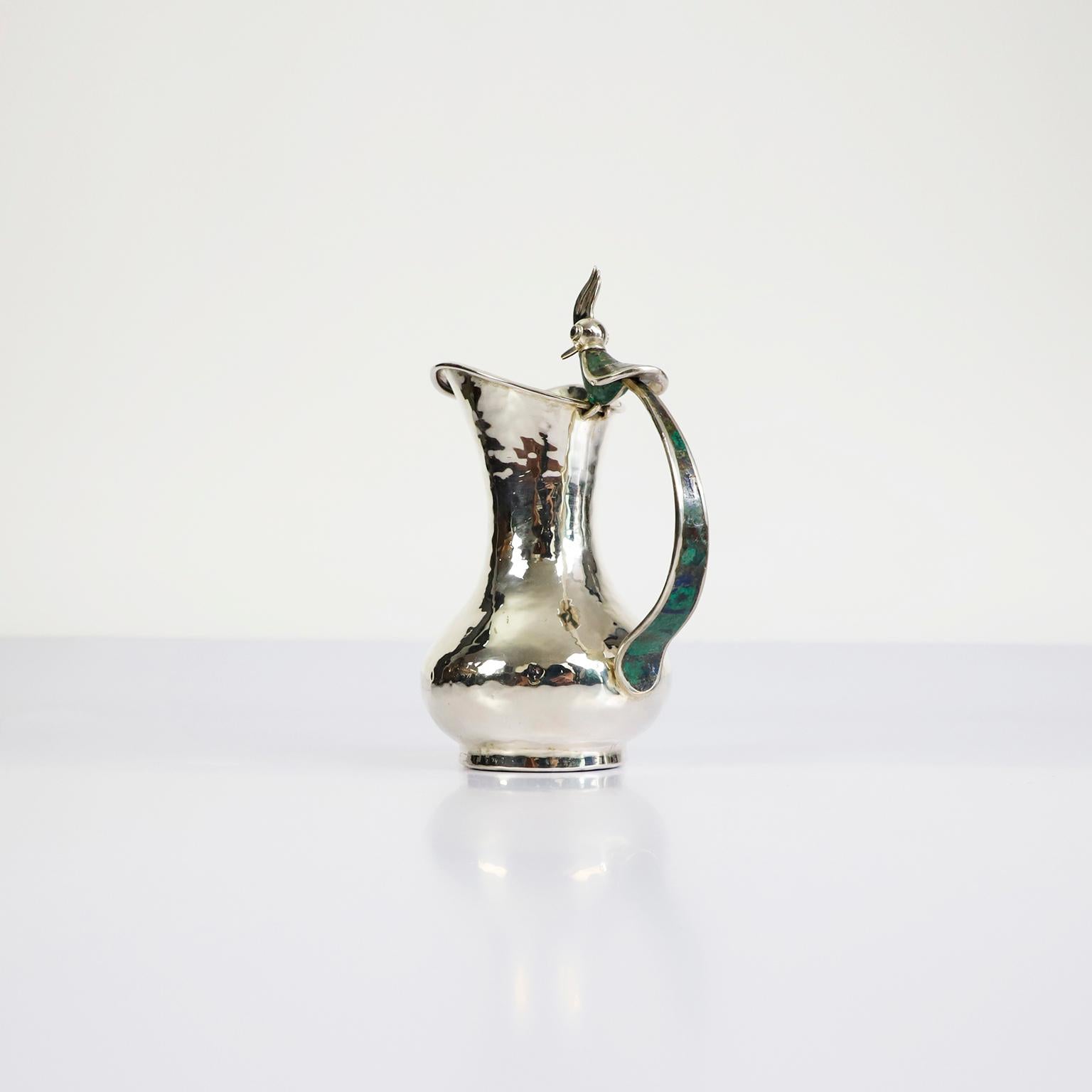 Circa 1960. We offer this Mid-Century Modern Mexican silver malachite pitcher sporting an amazing handle in a bird motif by Los Castillo Taxco México. The pitcher Marked Los Castillo Taxco Mexico, in excellent condition.