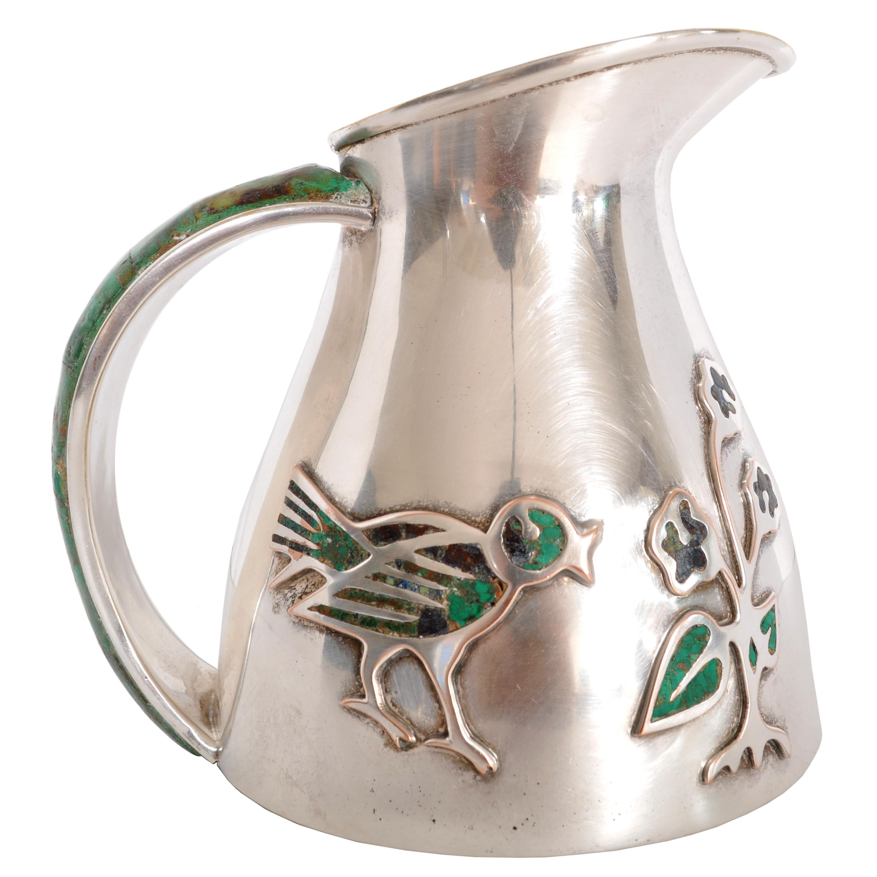 Mid-Century Modern pitcher/ jug, made by Los Castillo of Mexico, circa 1960. The pitcher having an inlaid malachite handle and a design to the front of a small bird and a plant, the design also inlaid with malachite. The pitcher is fully marked to