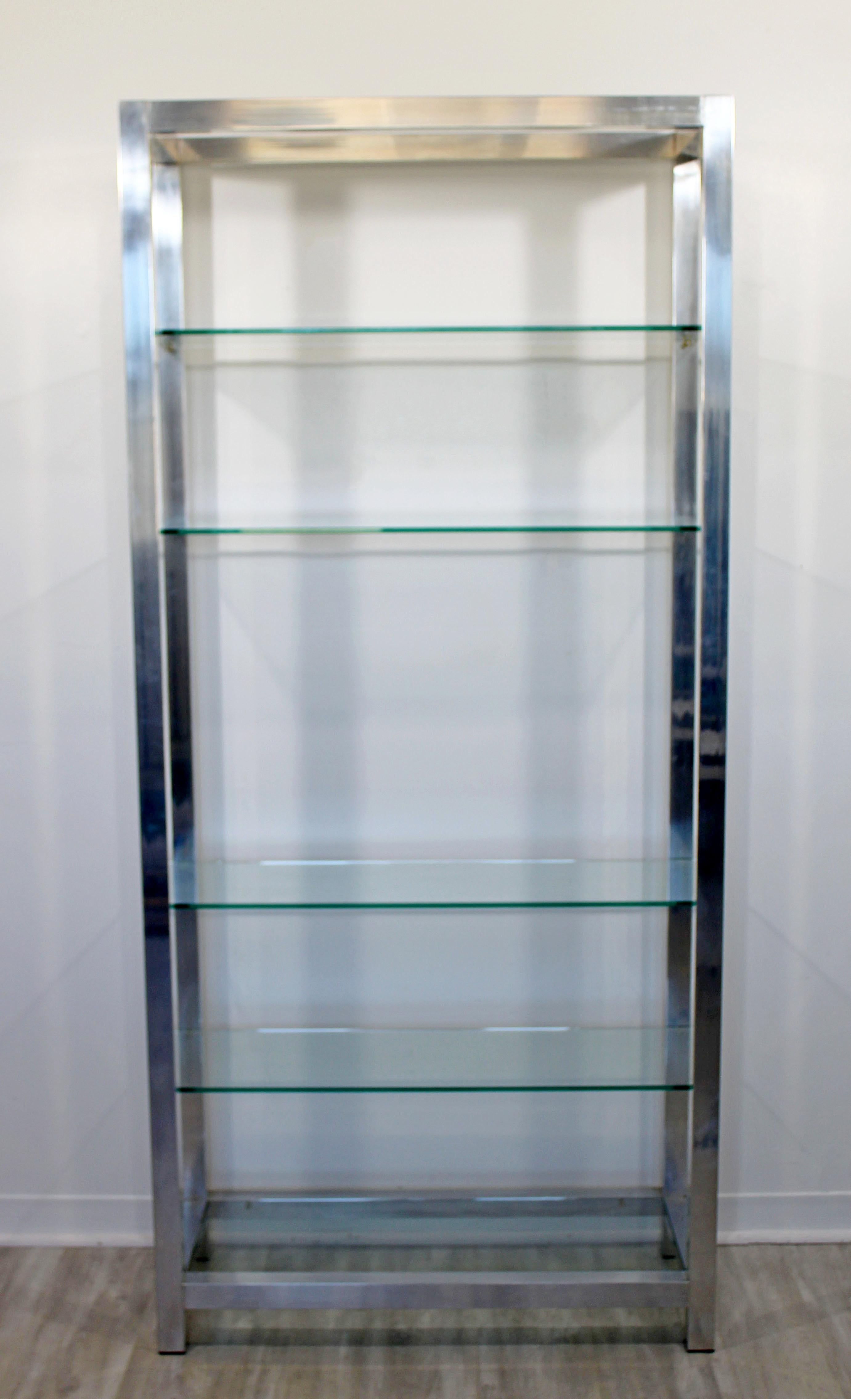 For your consideration is a Classic, aluminum shelving unit étagère, with five glass shelves, circa the 1970s. In very good condition, with a blemish in a shelf and some scuffing on the aluminum. The dimensions are 36