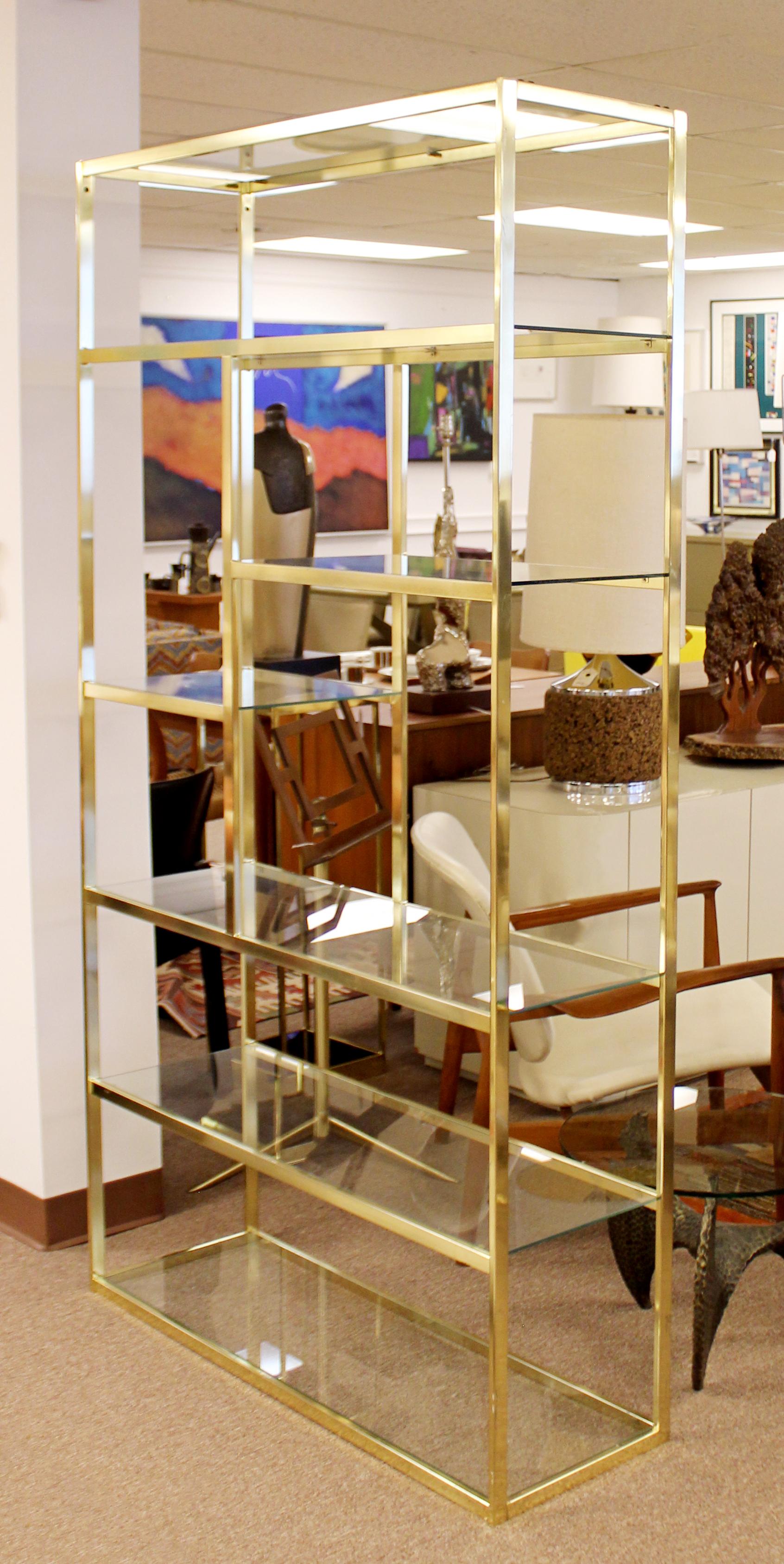 For your consideration is a stunning, brass shelving unit étagère, with seven glass shelves, circa 1970s. In very good condition, with some scuffing and natural patina on the brass. The dimensions are 41.5