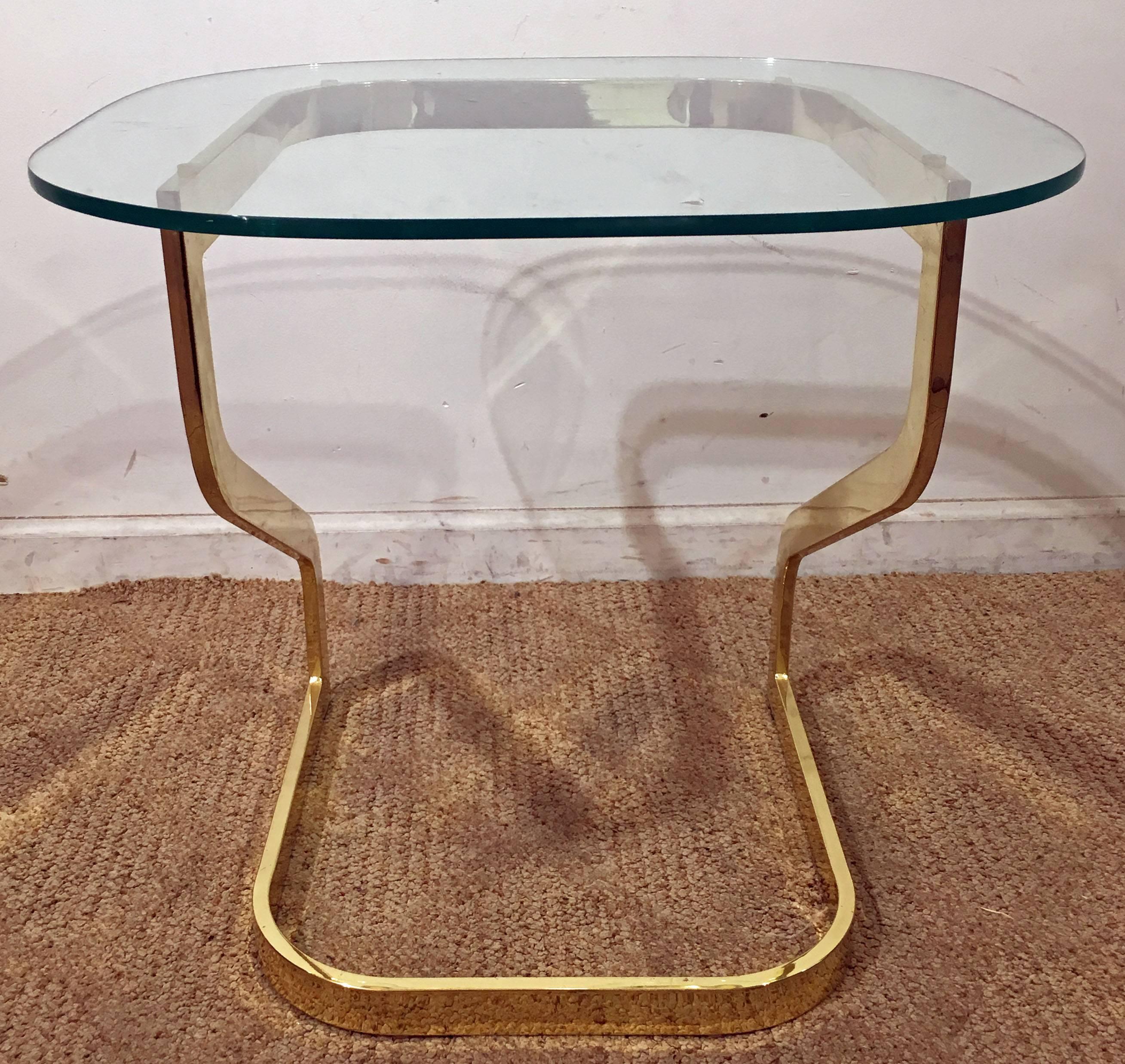 This piece was designed by Milo Baughman. It features a glass-top and golden chrome base. The top is removable.