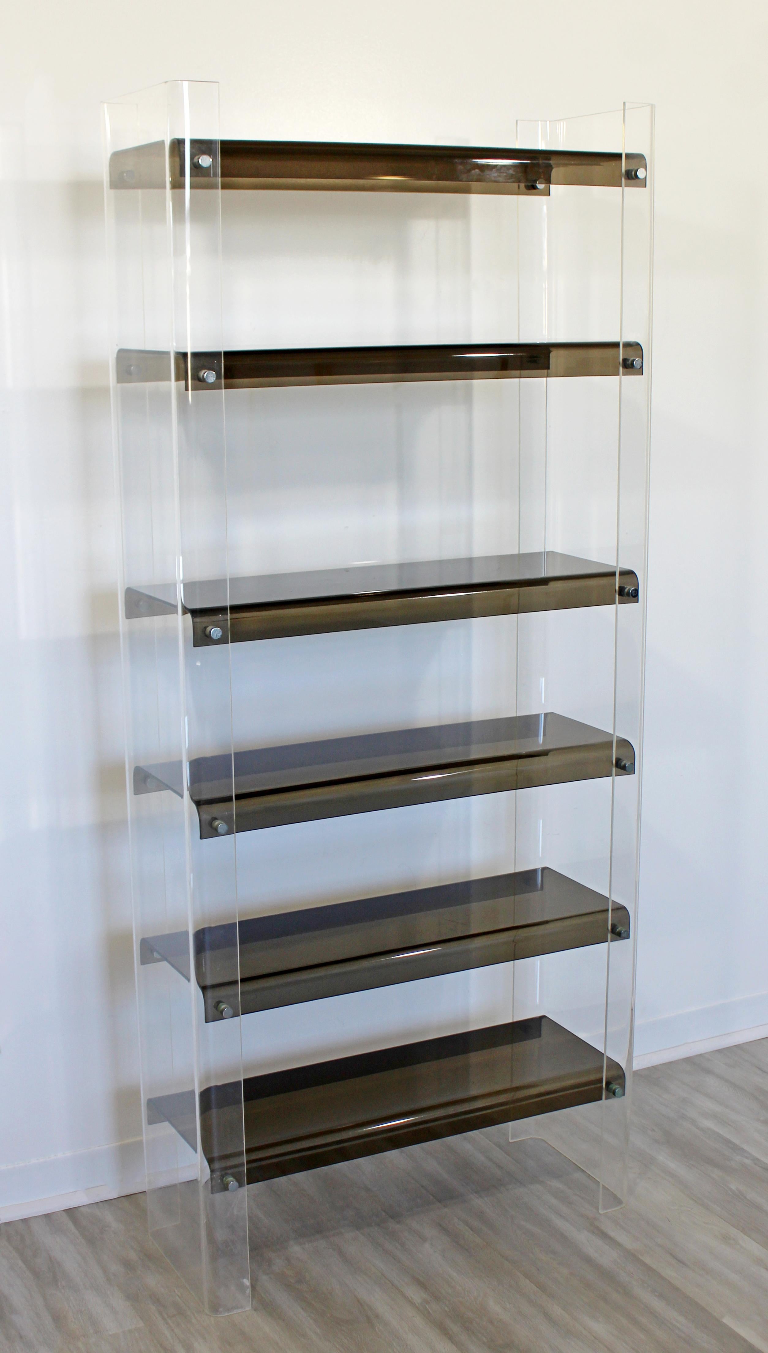 For your consideration is a Classic and chic, smoked and clear Lucite shelving unit, étagère, bookcase, with six shelves, circa 1970s. In excellent condition. The dimensions are 30