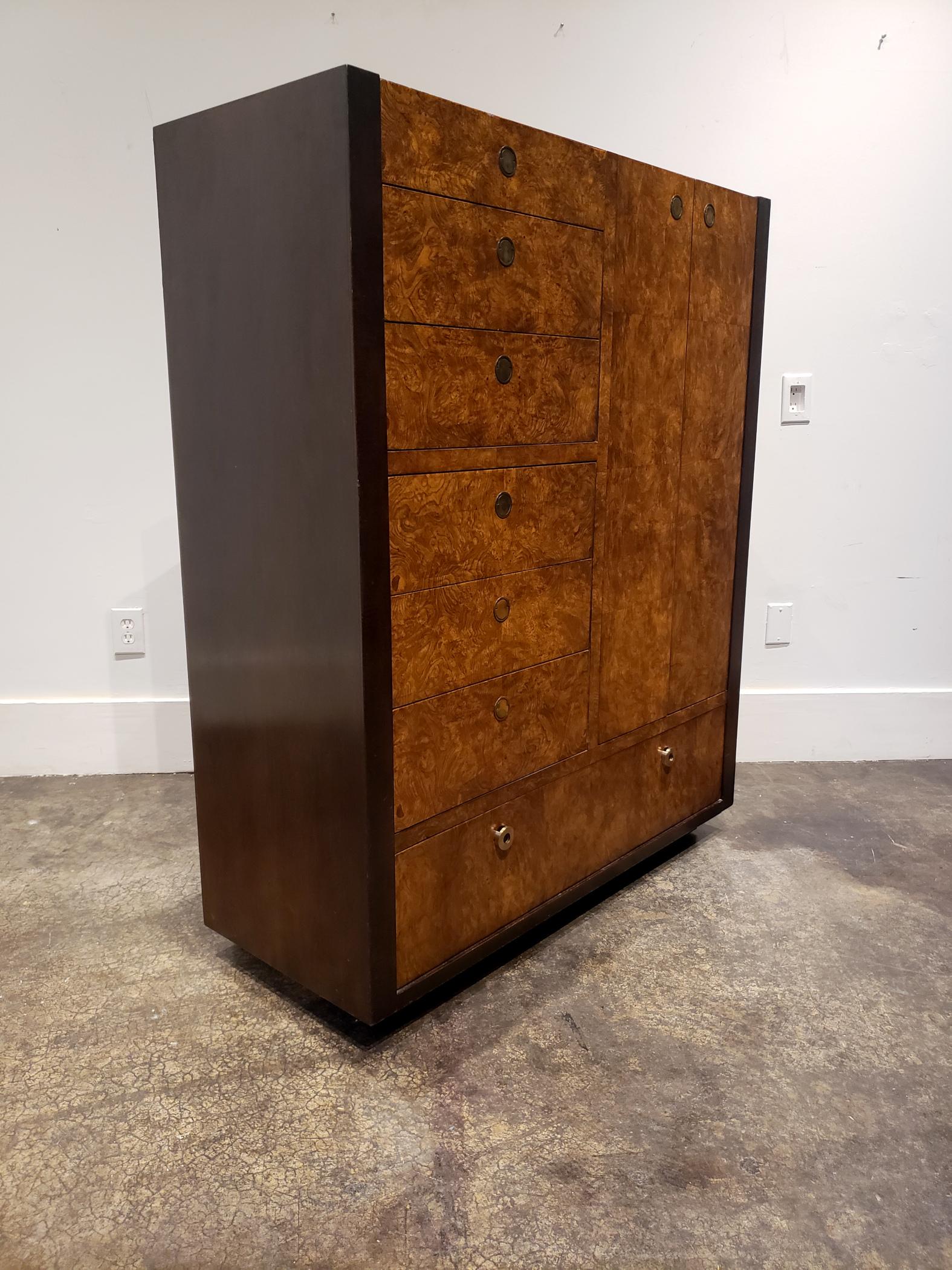 Milo Baughman style 1970s high chest with dark walnut stained sides, beautiful burl wood veneer on front, and brass pulls. Stylish storage piece with 6 pull out drawers on the left side, 1 large pull out drawer at bottom and large cabinet space on