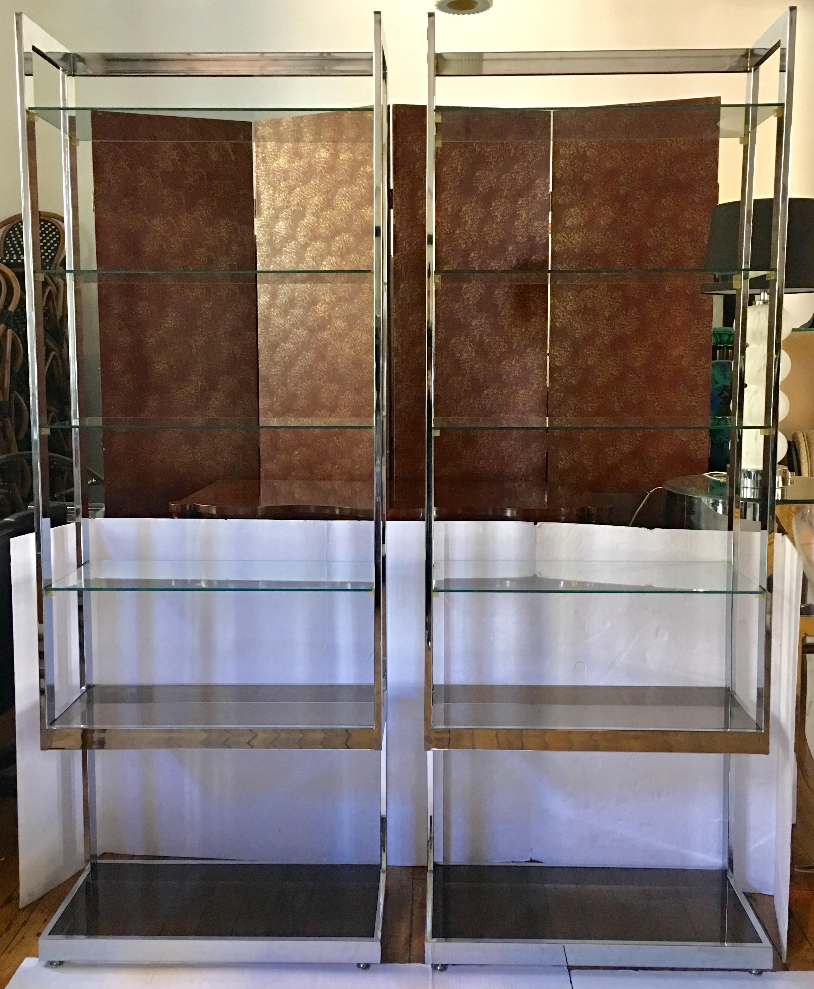 Mid-Century Modern Milo Baughman style flat bar polished chrome etageres. These 1970s Hollywood Regency style display shelving bookcase units feature two removable smoked glass bottom shelves and four removable clear glass upper shelves. Each