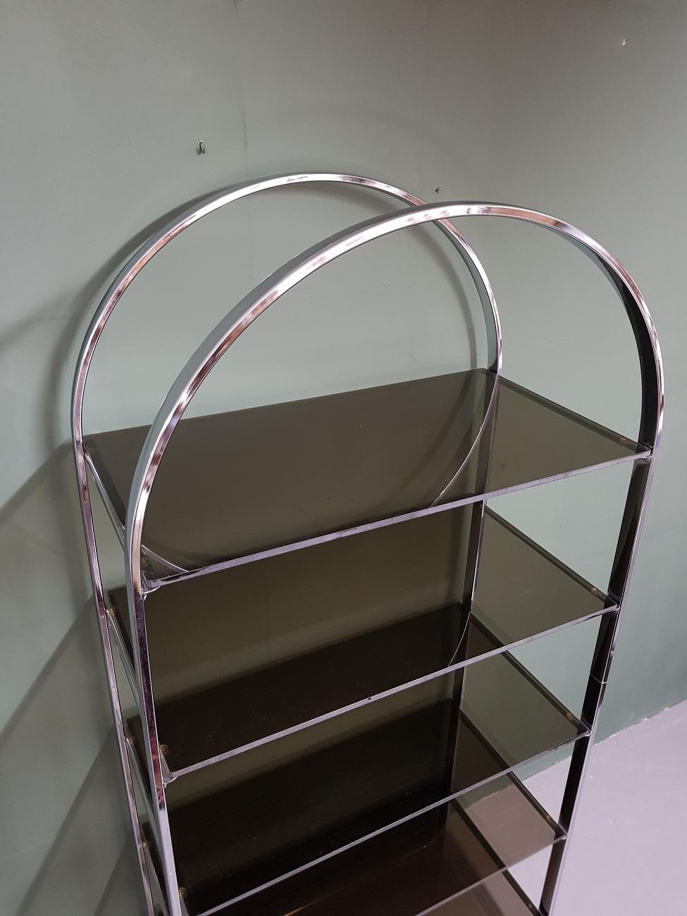 Mid-Century Modern vintage Milo Baughman style chrome etagere with five smoked glass shelves from the 1970s, some glass shelves have a few chips and the frame has light oxidation spots.

The measurements are:
Depth 43.5 cm/ 17.1 inch.
Width 84.5 cm/