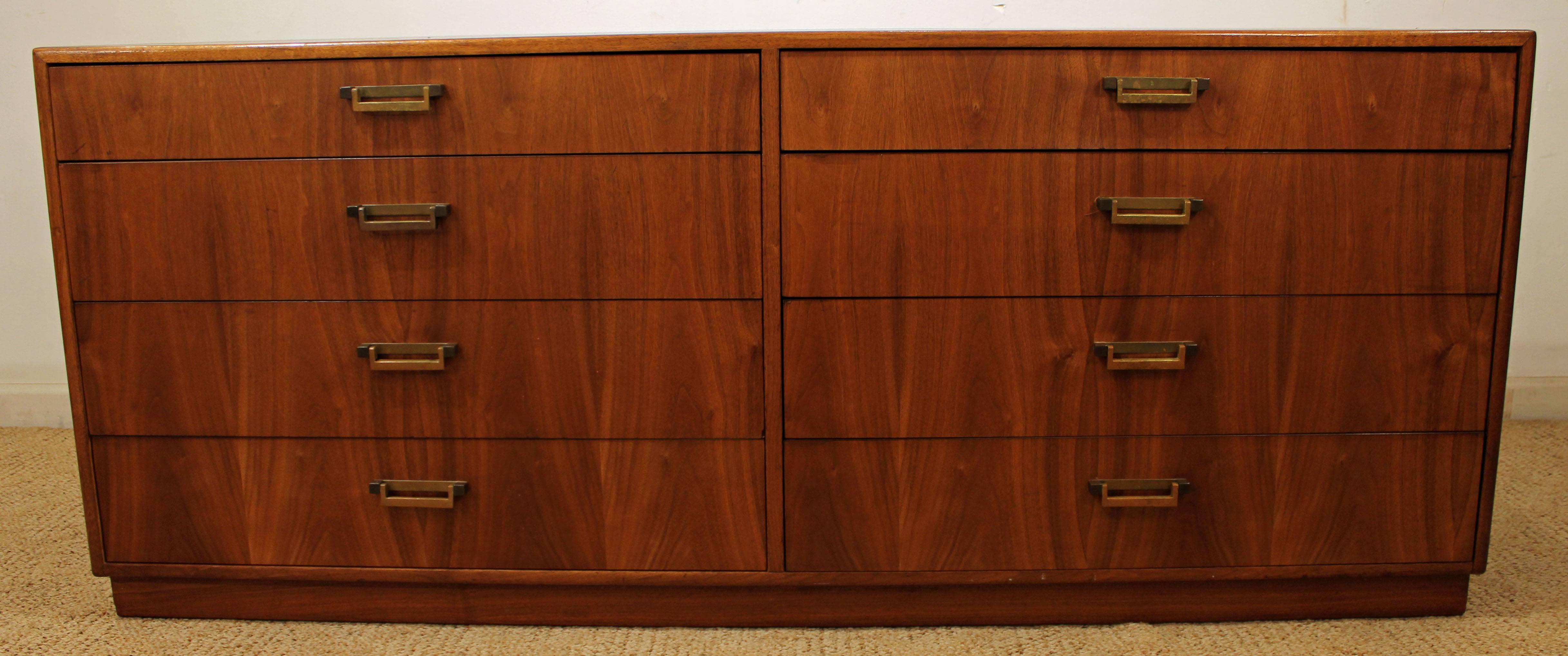 Offered is a Mid-Century Modern credenza made for Founders. It is made of walnut and a burl wood-face with brass pulls. Includes eight dove tailed drawers. We believe it was designed by Milo Baughman, but do not have documentation. Has been