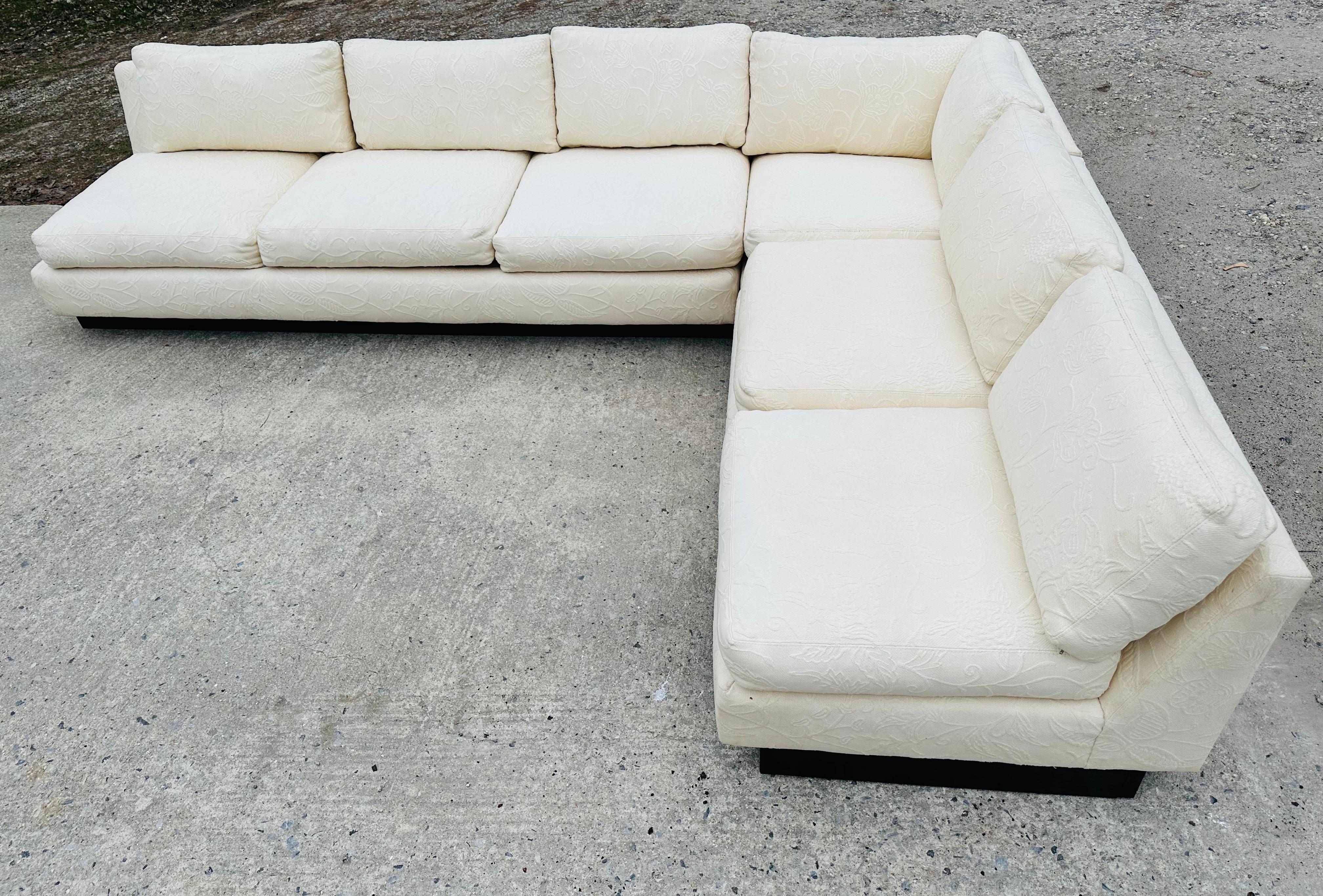 This listing is for a Mid-Century Modern sectional sofa. Featuring an off-white floral upholstery, three pieces that connect into an L-Shaped armless Milo Baughman style design, removal cushions, and a black plinth base.