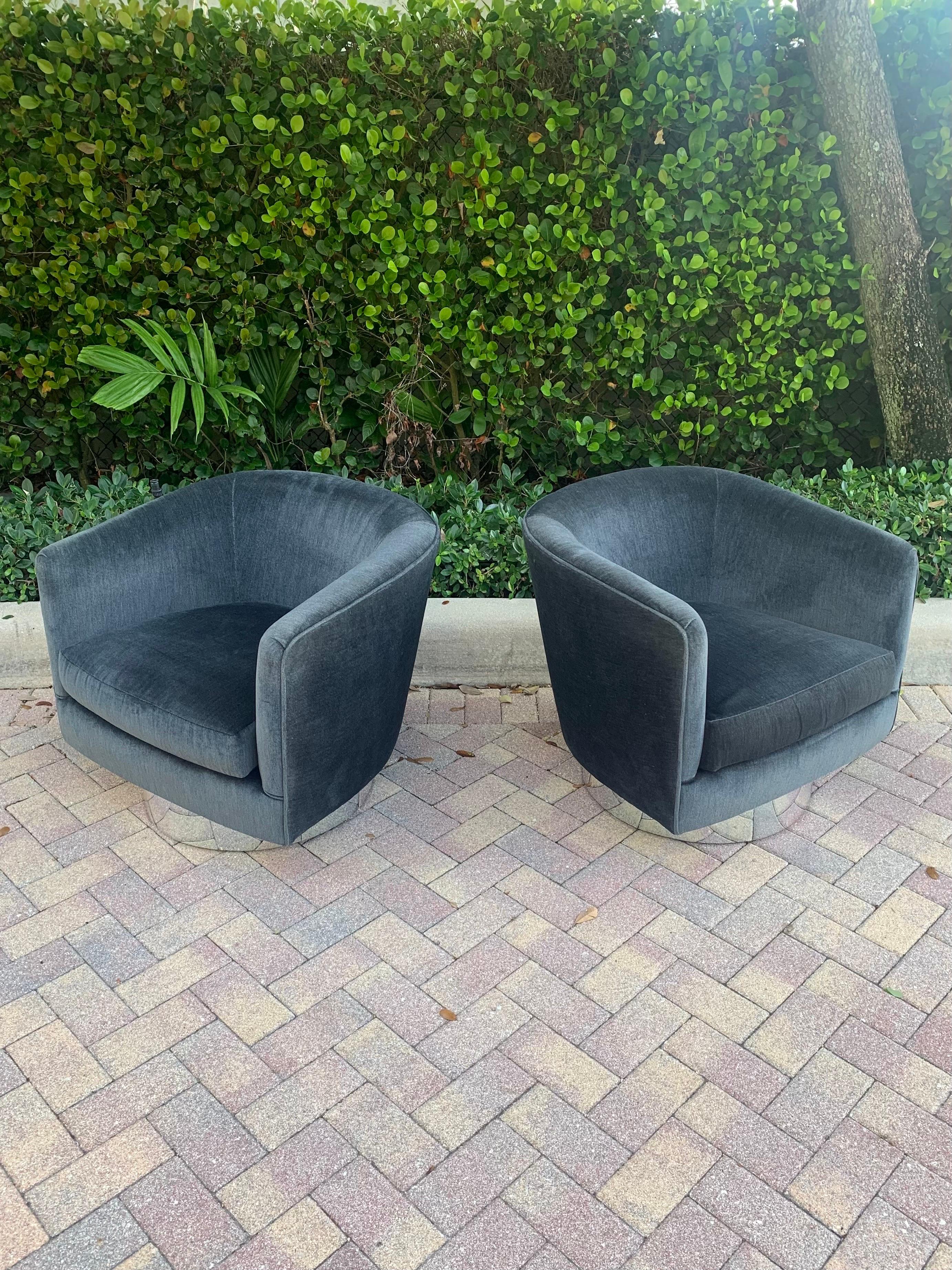 Beautiful pair of swivel lounge chairs in the style of Milo Baughman. Chairs share the same dimensions as his Papa Roxy chairs for Thayer Coggin however they do not tilt. Each chair has a circular design for the back and arm rests and well defined