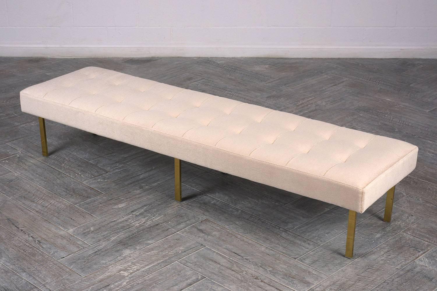 This Mid-Century Modern style Milo Baughman bench has been professionally upholstered in a beige Mohair fabric with a square, top-stitch tufted design. The bench features six solid brass legs finished in a stunning gold color. This bench is sturdy,