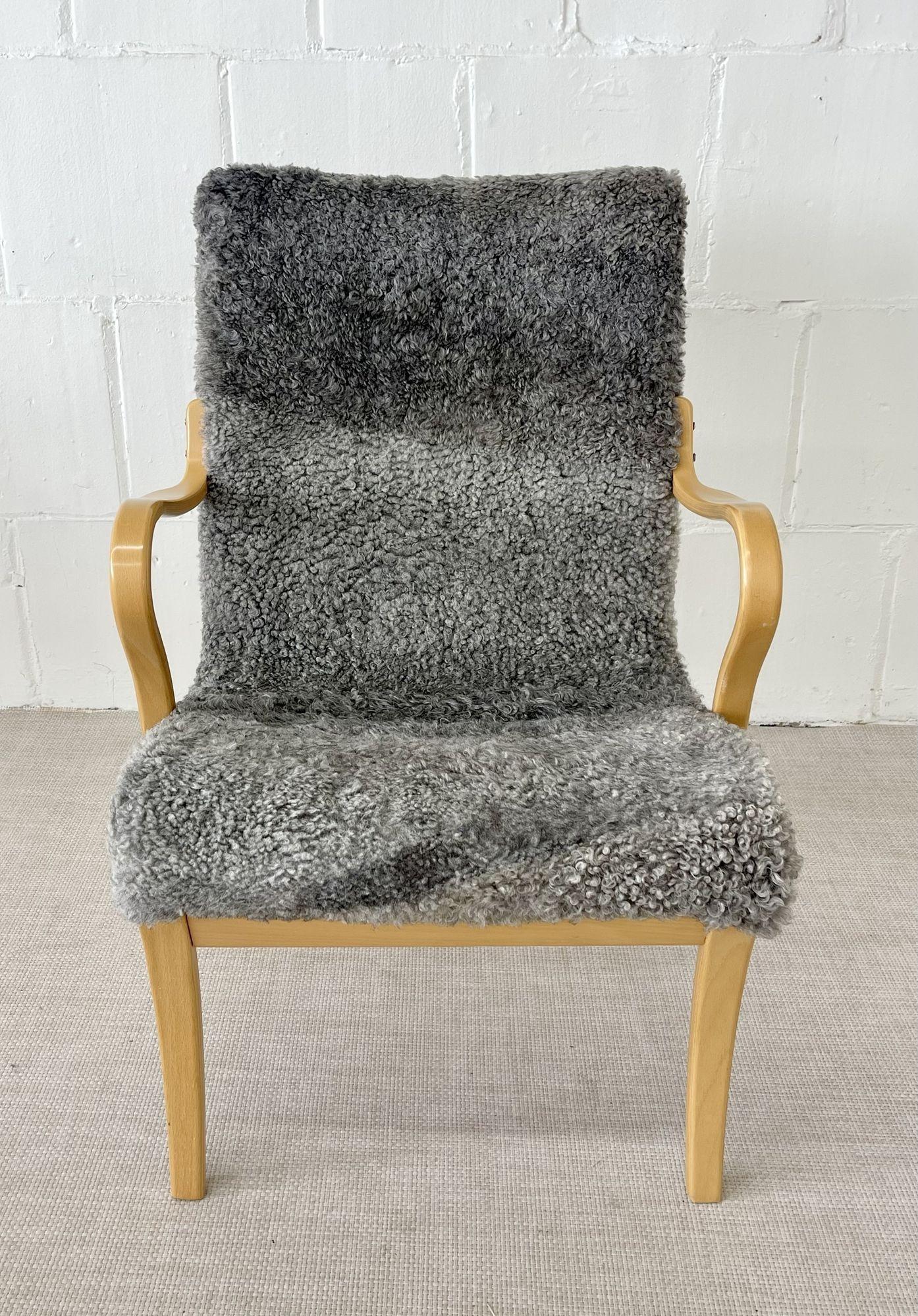 Mid-Century Modern 'Mina' lounge / arm chair stamped Bruno Mathsson, Sweden, 1950s
 
Iconic Mid-Century seating in later sheepskin over textile upholstery. Manufactured and burn mark stamped by Bruno Mathsson International in Sweden in the 1950s. 
