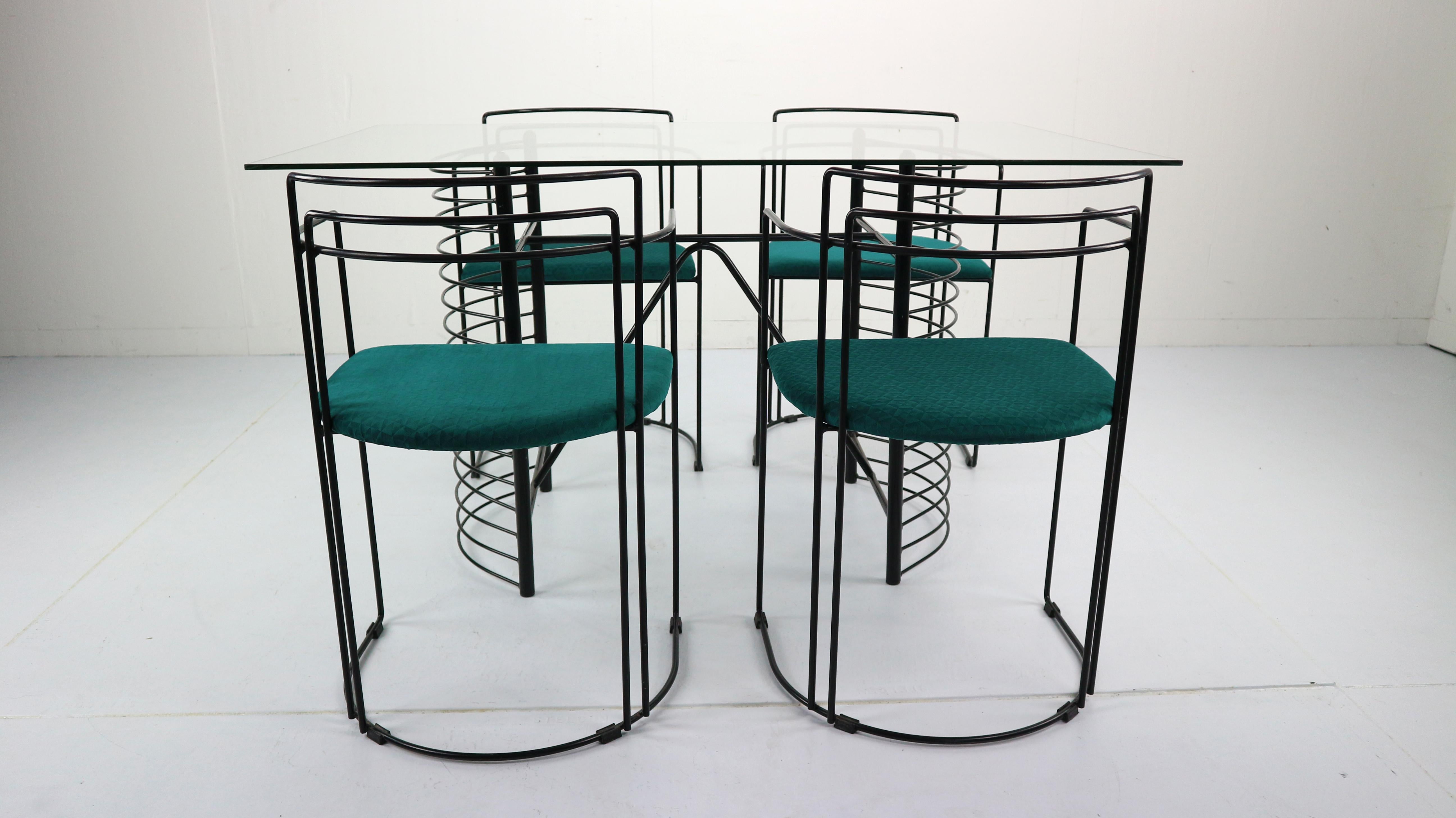 Rare Minimalist and modern design dining room set comes from 1980s Italy. An eyecatcher for your home.
Set comes with glass top dining table and four chairs.
Chairs are made from black wire and satin petrol color fabric.
Dining table measurement:
