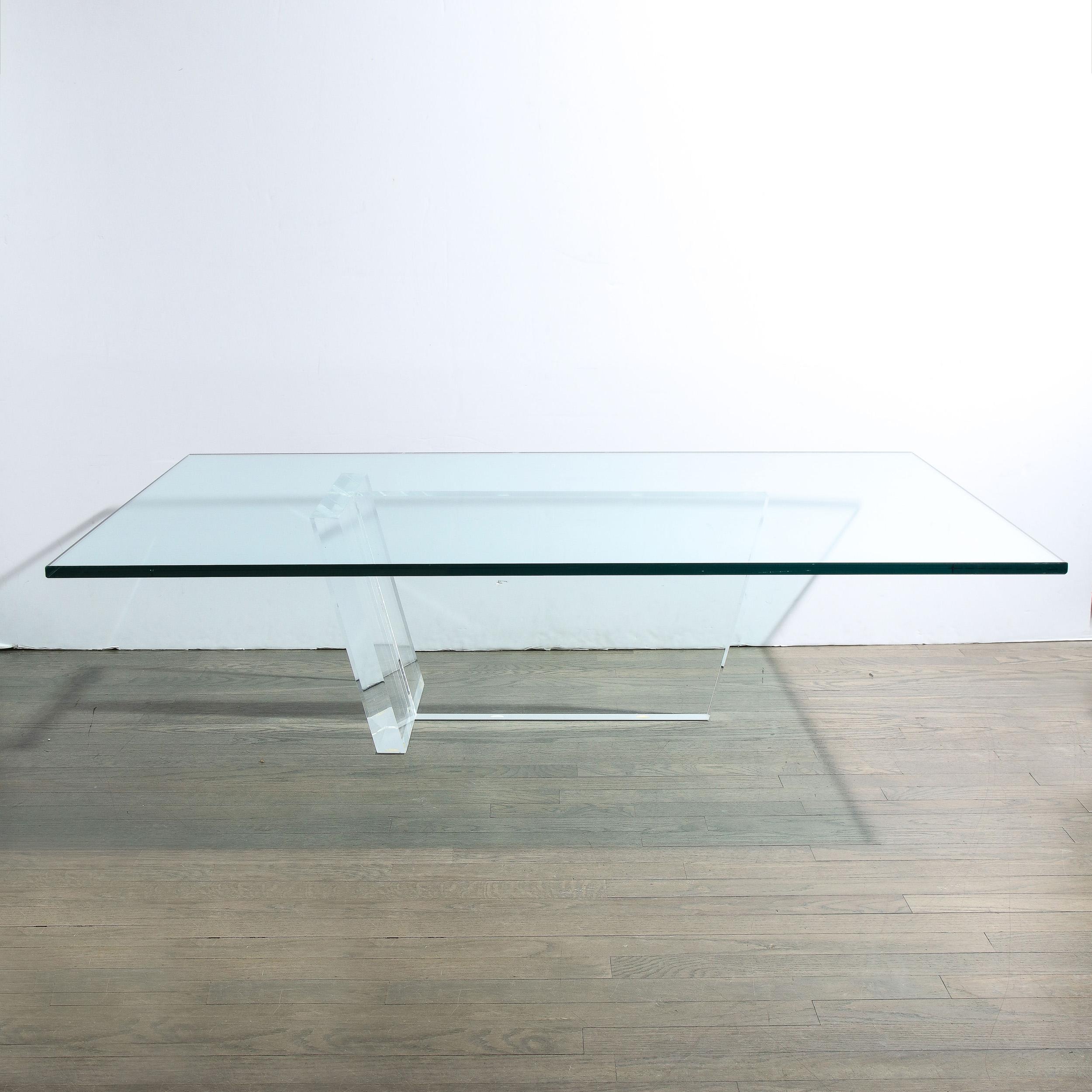 This refined Minimalist Mid-Century Modern cocktail table was realized in the United States circa 1970. It offers a trapezoidal central form in translucent Lucite with angled sides that is adjoined on one side at a right angle by another rhombus