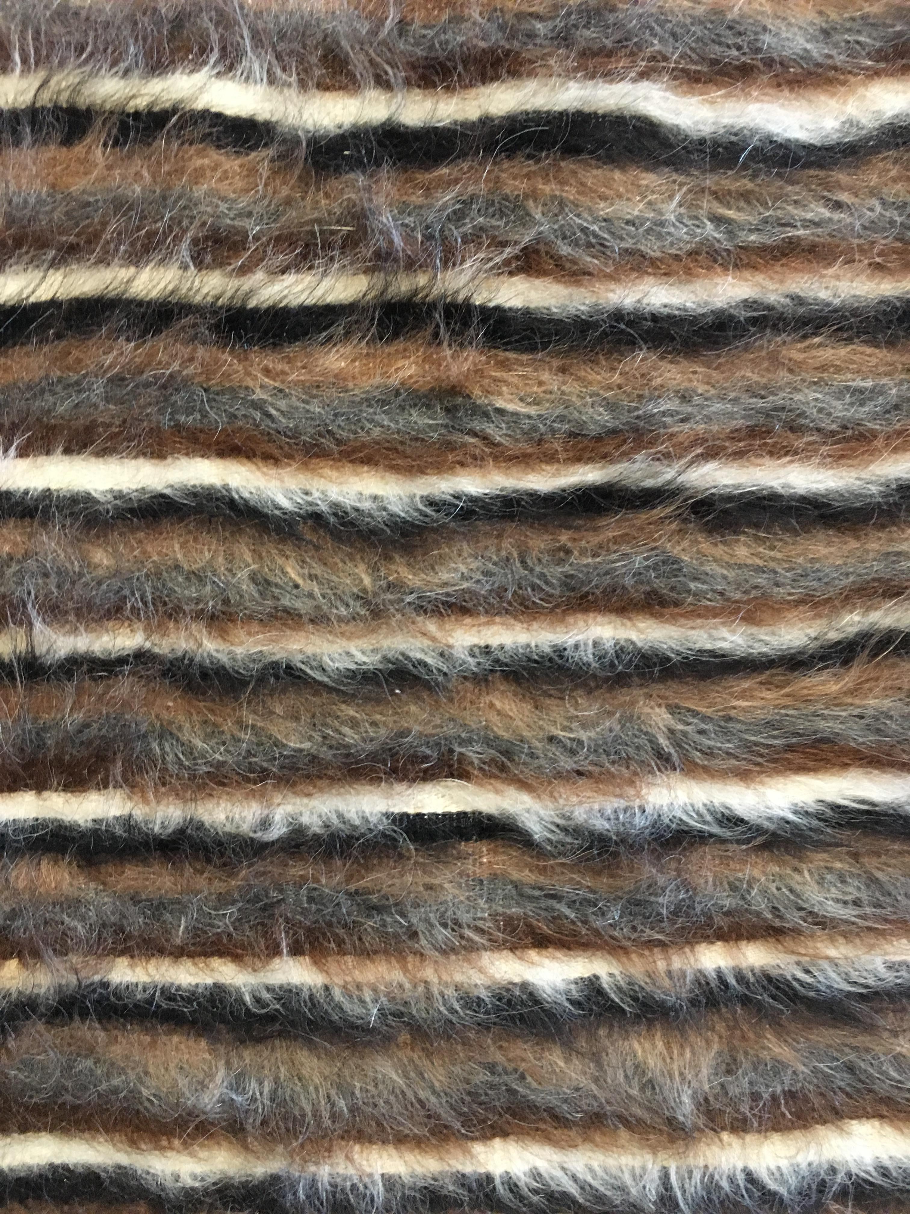 Tissé à la main dans l'est de la Turquie, ce petit tapis tout neuf a une base en coton et un doux poil de chèvre (mahair) composé de couleurs naturelles et non teintées de brun noir et d'ivoire. 
Il est très doux et souple et peut donc être utilisé