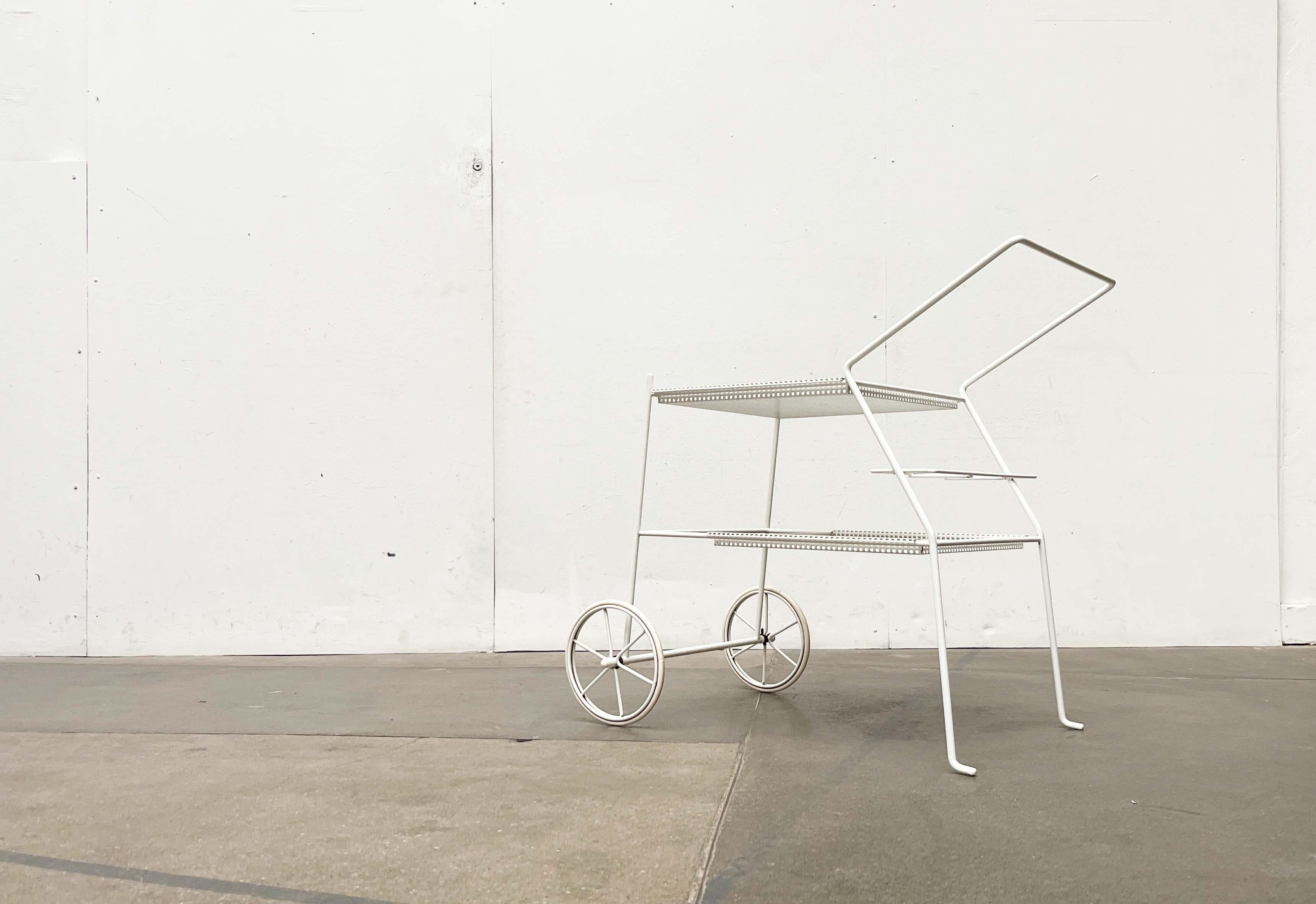 Chariot de bar délicat avec de remarquables éléments en métal perforé.

Avec sa palette de couleurs entièrement blanches et ses lignes épurées, ce design poursuit une esthétique minimaliste. Des étagères amovibles en métal perforé plié sont insérées