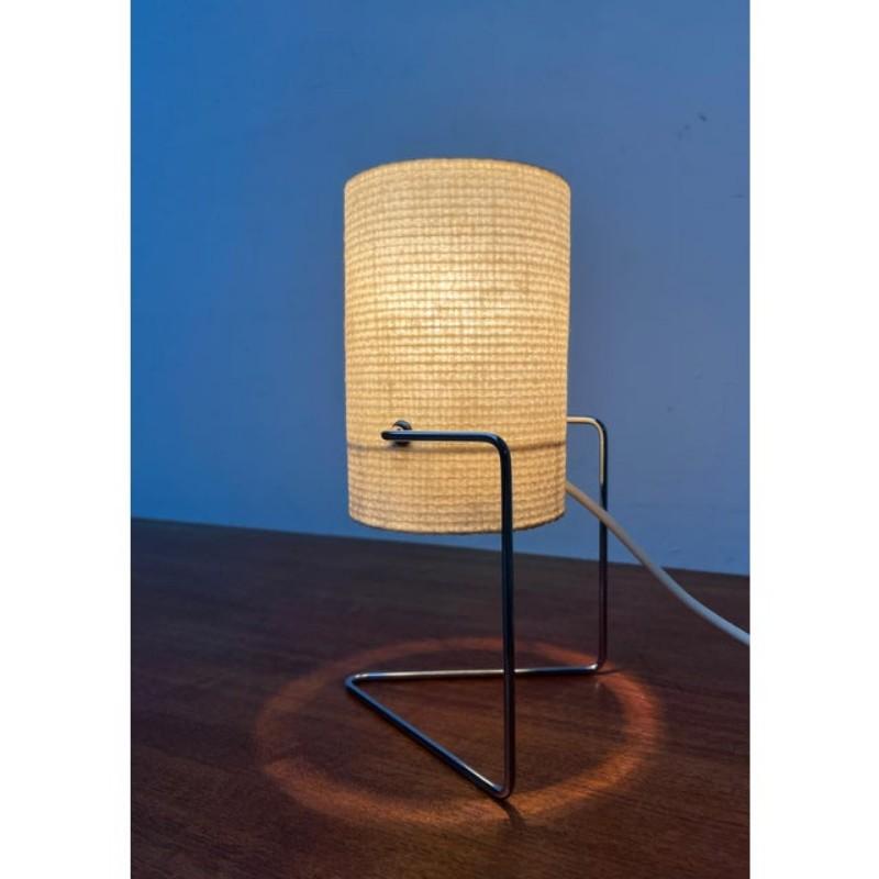 Lampada da tavolo in filigrana della metà del secolo scorso.

Un design minimalista. La costruzione conferisce a questo design una particolare leggerezza. La base si spezza in una staffa composta da un'asta di metallo cromato. Il paralume ha una