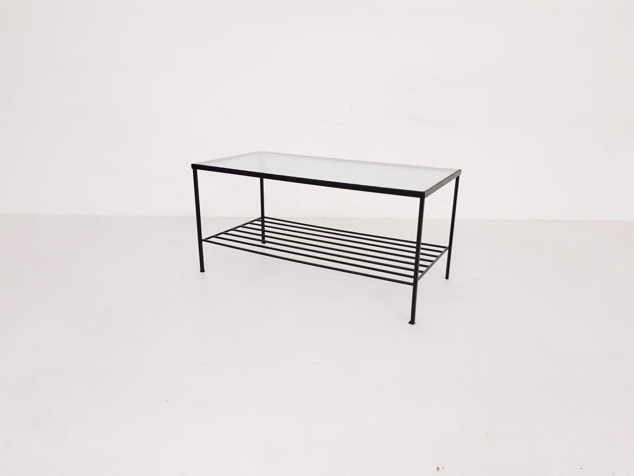Black metal minimalistic frame with magazine rack and a bubbled glass top.
Design from the Netherlands in the 1950s.

   