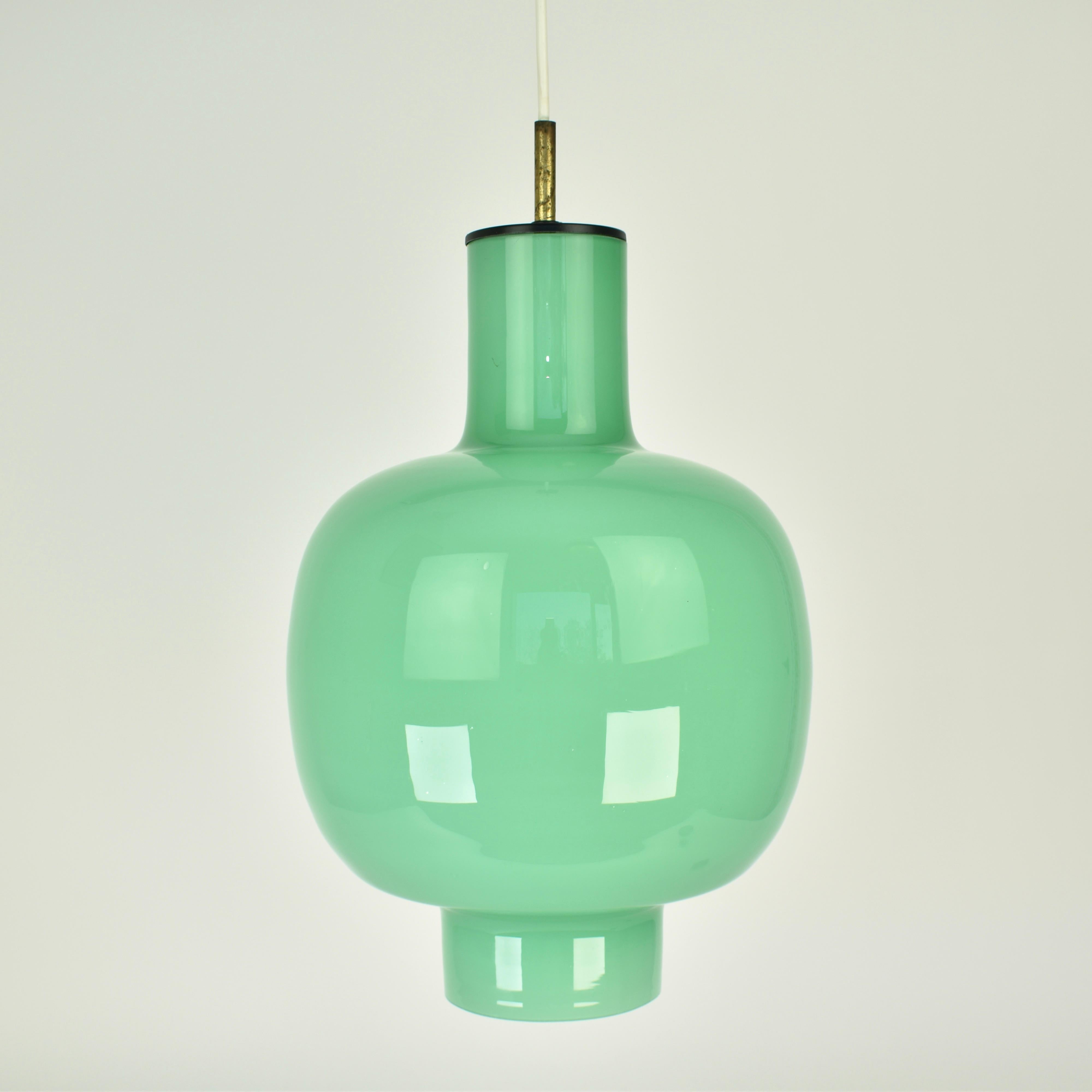 Splendida lampada a sospensione di metà secolo in vetro verde menta. Attribuito a Gino Vistosi, ma purtroppo non marcato. Questo ciondolo è realizzato con la tecnica dell'incamiciato, per la quale Murano è molto conosciuta: il vetro è composto da