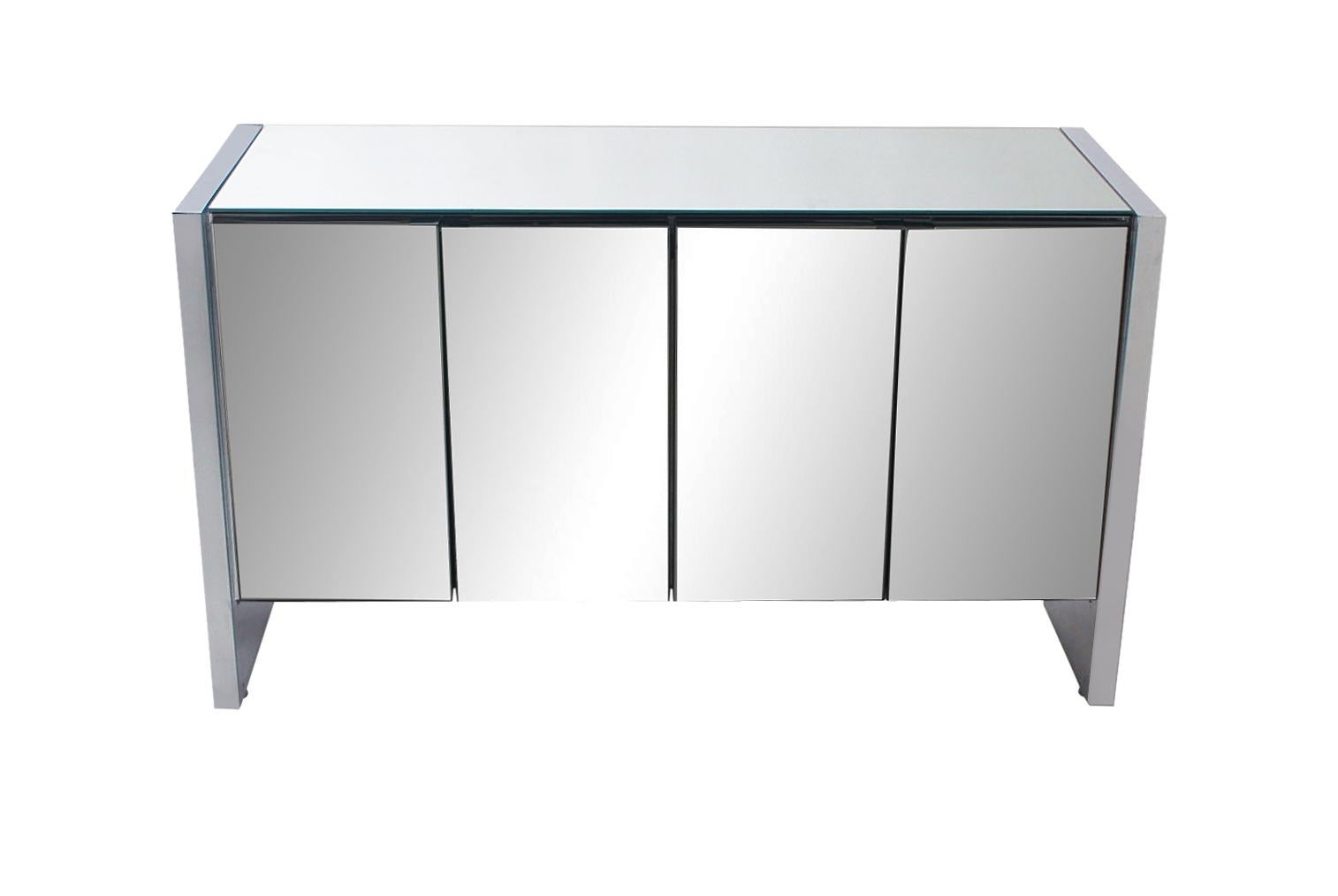 A sleek minimalist cabinet by Ello Furniture circa 1970's. It features mirror polished chrome sides, mirrored doors, mirrored top, and tons of storage. Clean and ready to use.
