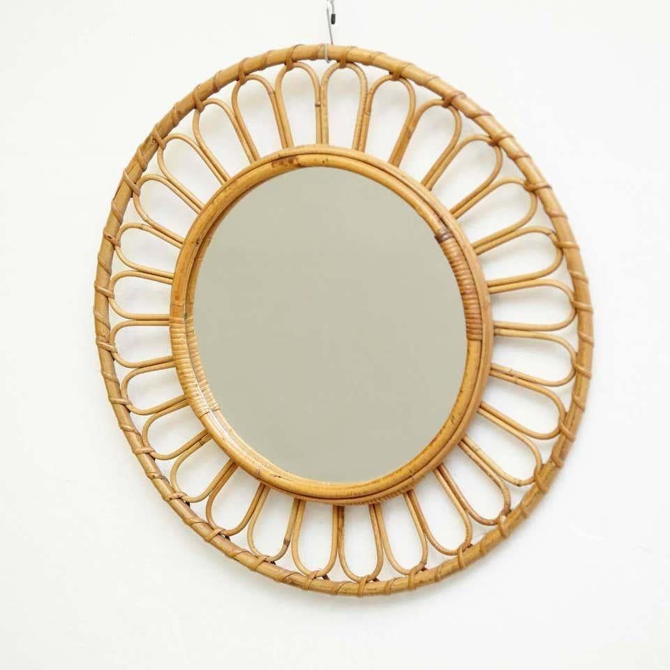 Specchio da parete in rattan artigianale francese del Mid-Century Modern.
Di un artigiano sconosciuto, circa 1960.
In condizioni originali, con lievi usure dovute all'età e all'uso, che conservano una bella patina.

Materiali:
Specchio
Bambù rattan