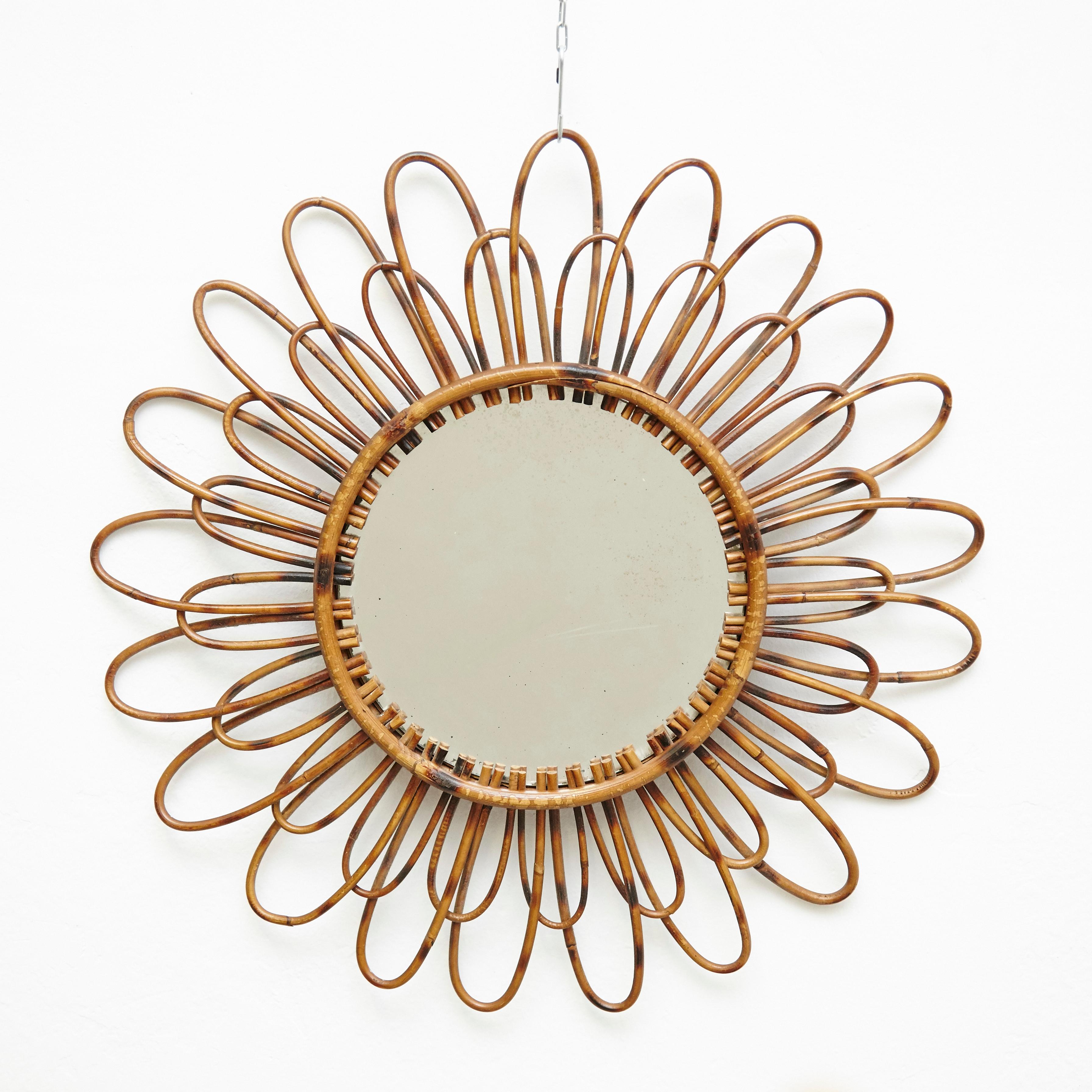 Mid-Century Modern French handcrafted rattan wall mirror.
By unknown artisan, circa 1960.
In original condition, with minor wear consistent with age and use, preserving a beautiful patina.

Materials:
Mirror
Handcrafted rattan