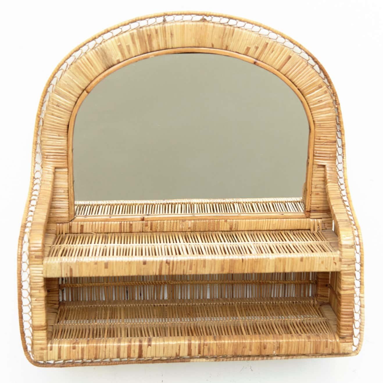 Introducing a timeless piece of Mid-Century Modern design, this handcrafted rattan mirror embodies the essence of the era. Created circa 1960, this mirror showcases the artistry and craftsmanship of an unknown designer, highlighting the beauty of