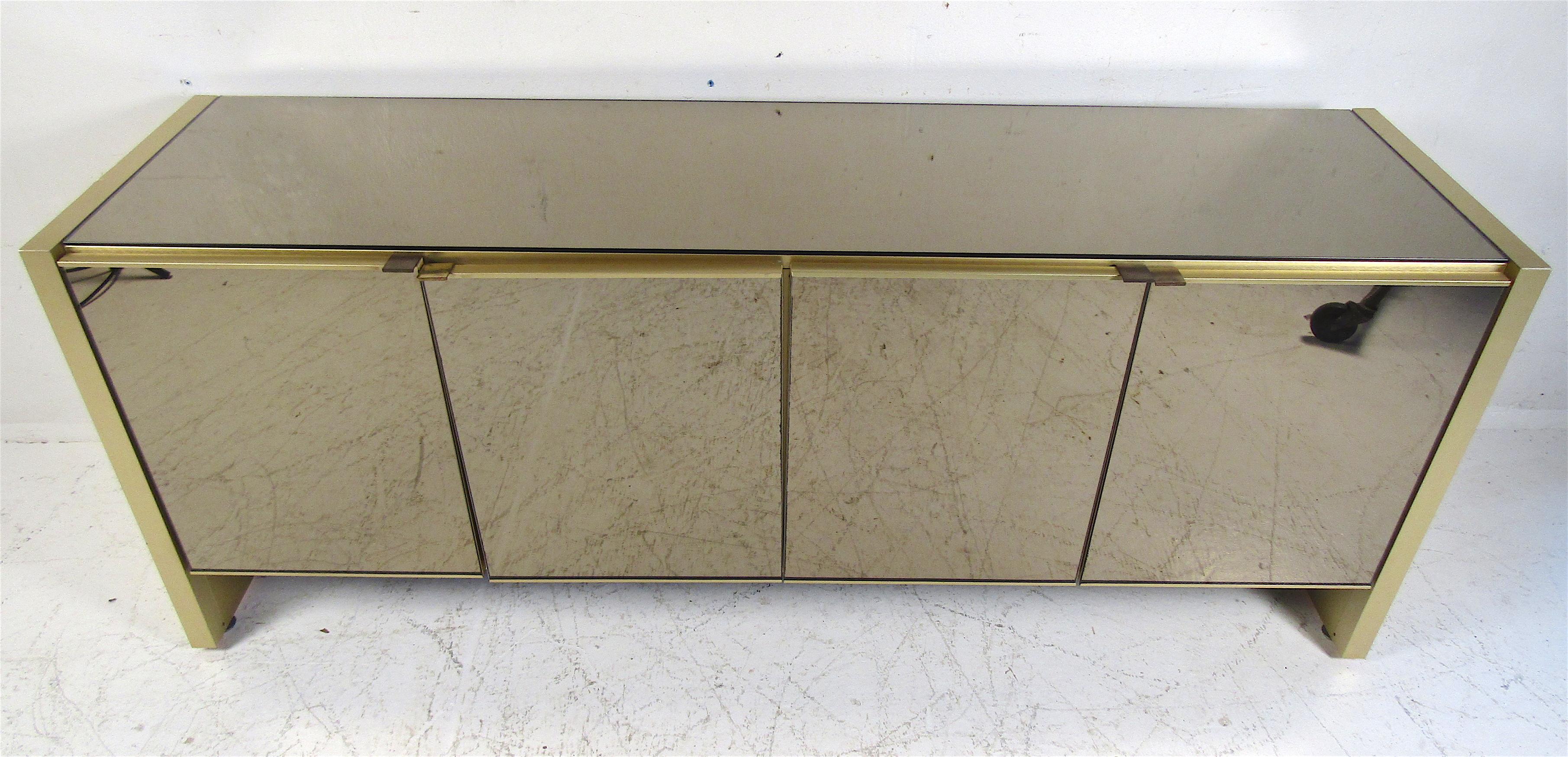 This stunning vintage modern credenza features ample room behind its four cabinet doors. A mirrored front and top makes this a unique addition to any home, business, or office. Please confirm item location (NY or NJ).